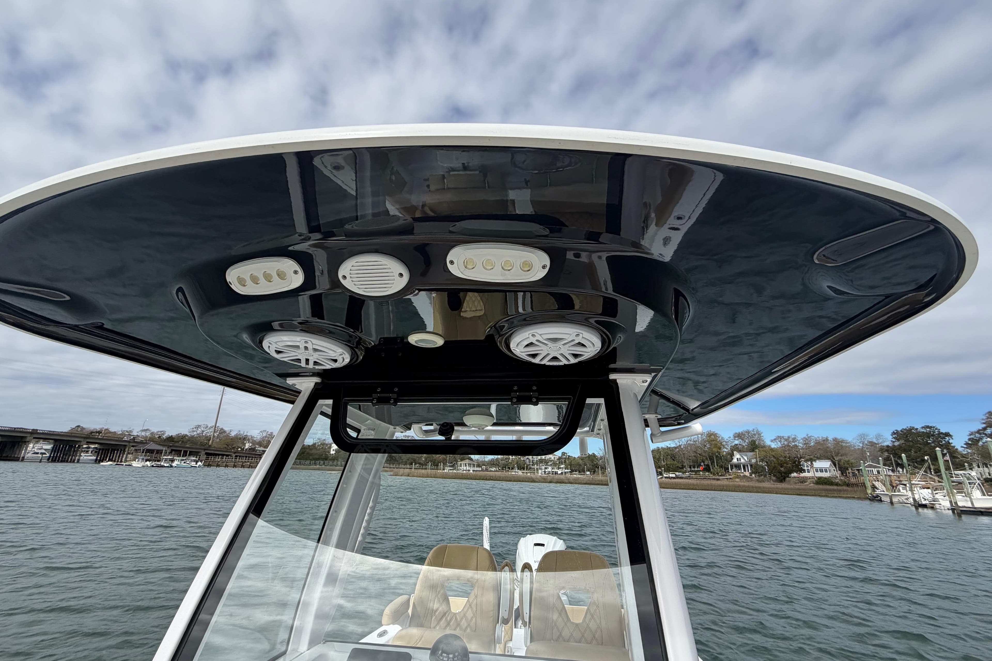 2023 Sportsman Masters 267 Bay Boat T-top with speakers and lights on a cloudy day.