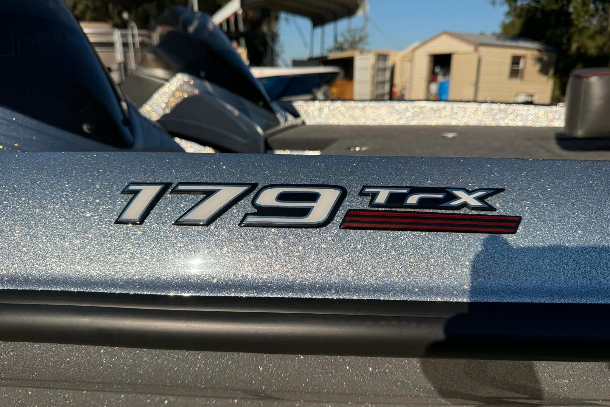 2026 Triton 179 TrX boat logo on a metallic surface, outdoor setting.