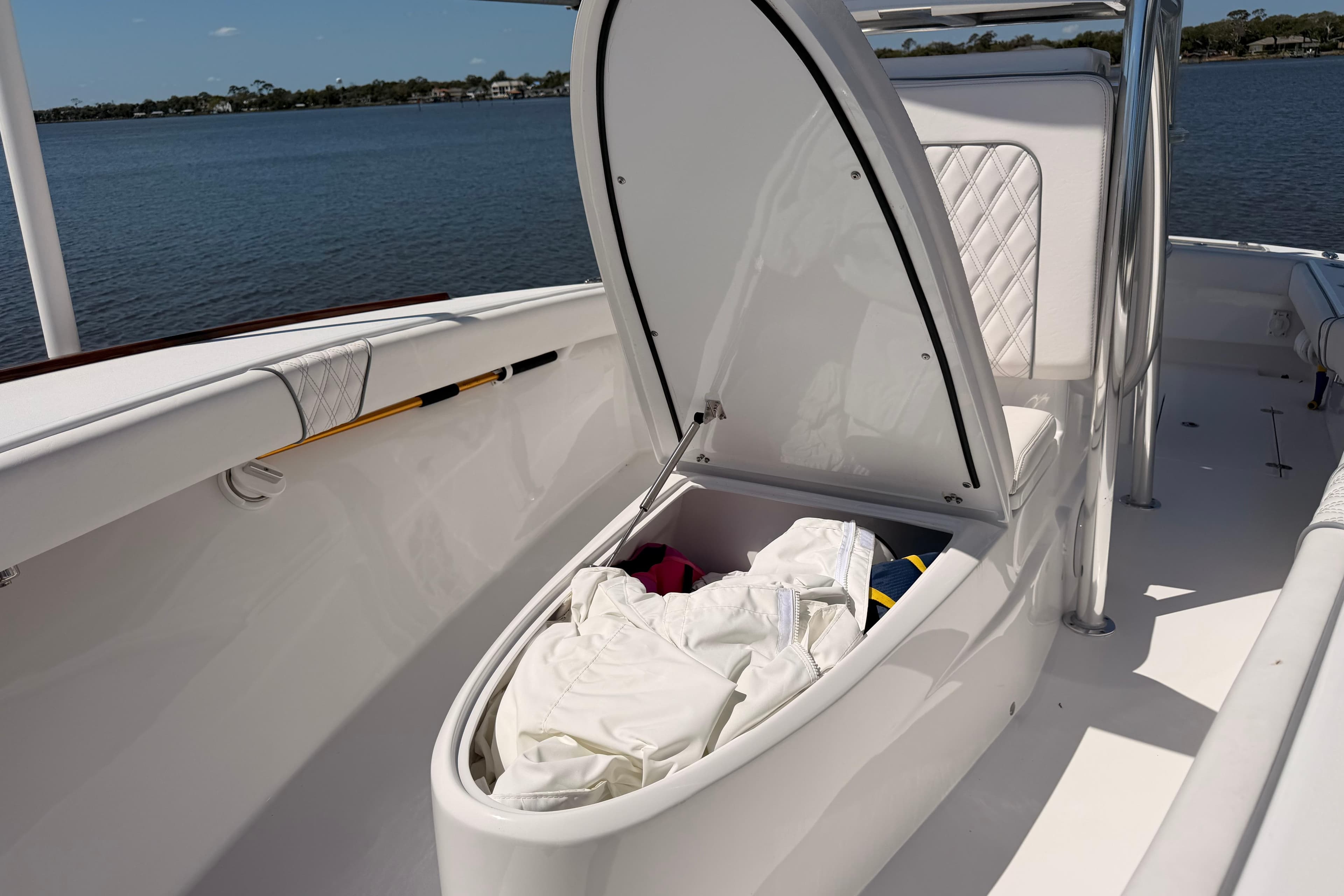2024 Stoner 23 CC boat with open storage compartment, docked by a serene lake.