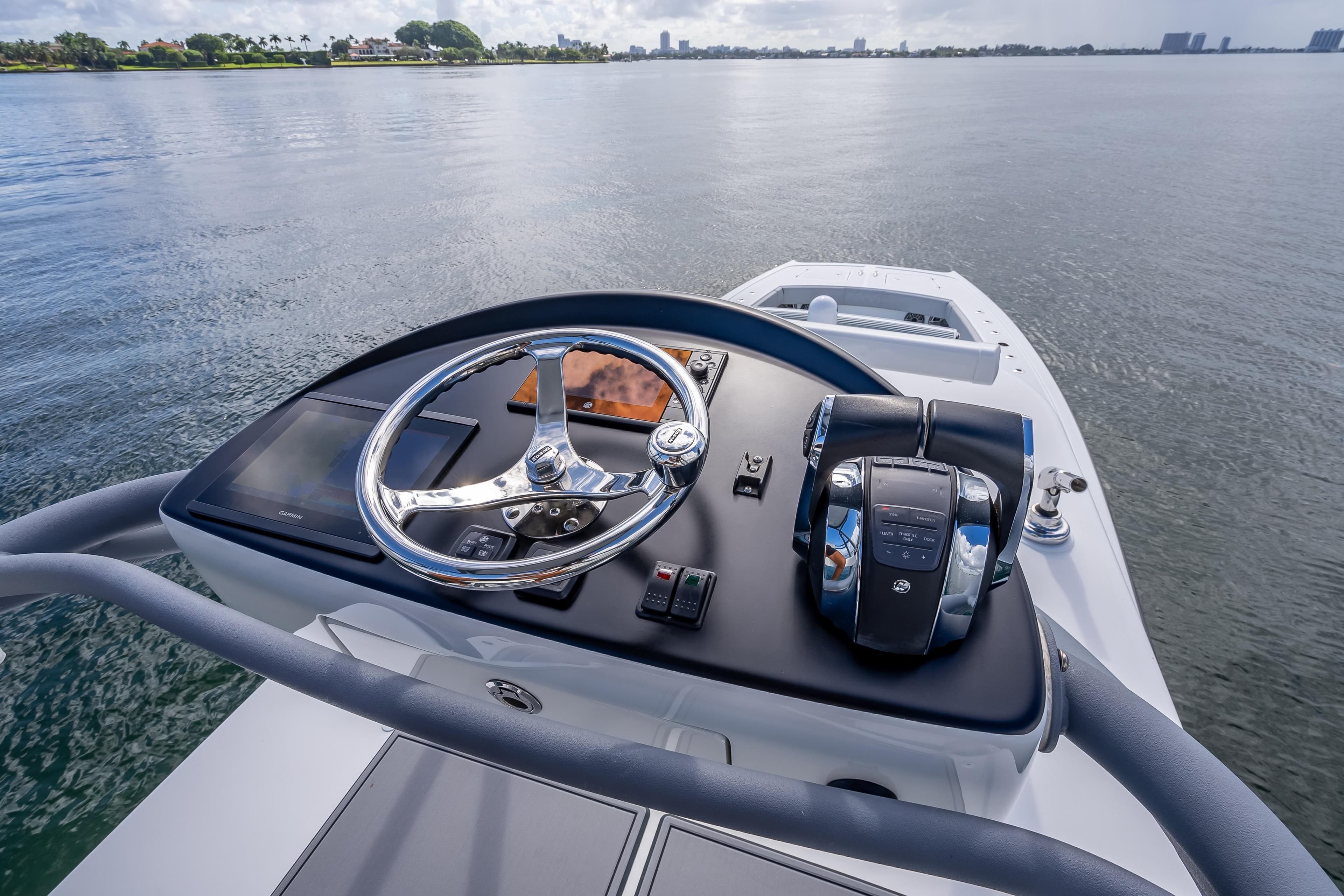 Helm of 2020 Freeman 42LR boat with steering wheel and controls on calm water.