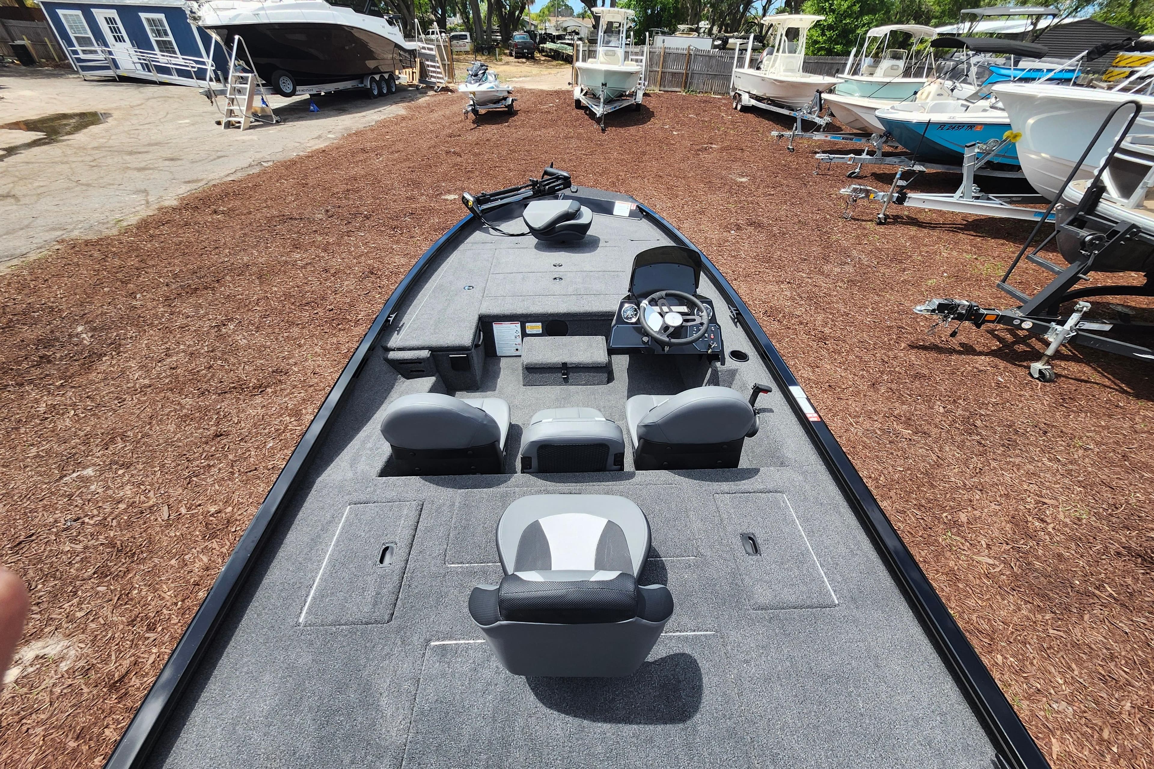 2026 Lowe Stinger 175C fishing boat with spacious deck and modern seating, parked outdoors.