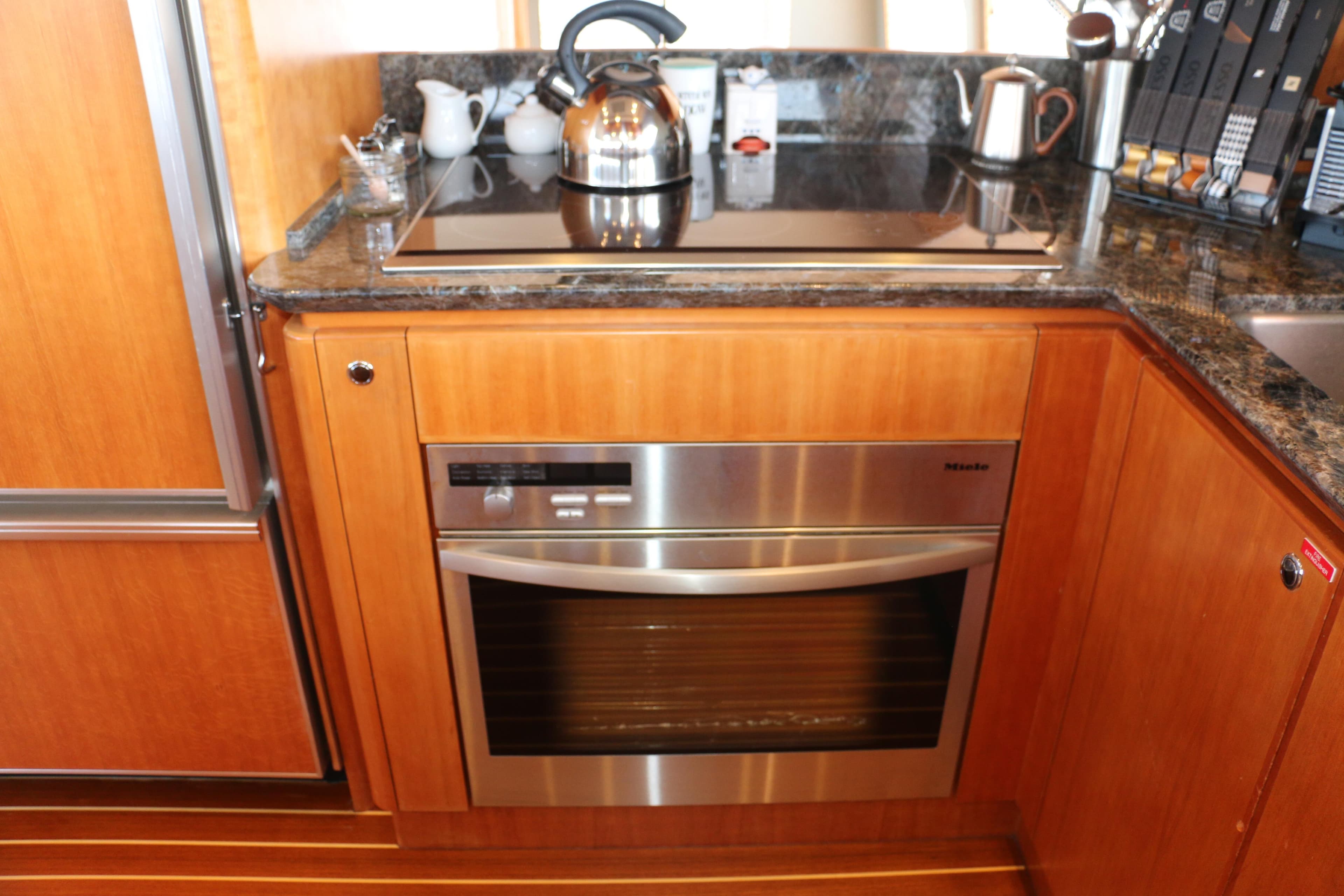 Modern kitchen in 2004 West Bay 68 Sonship Pilothouse yacht with stainless steel appliances.