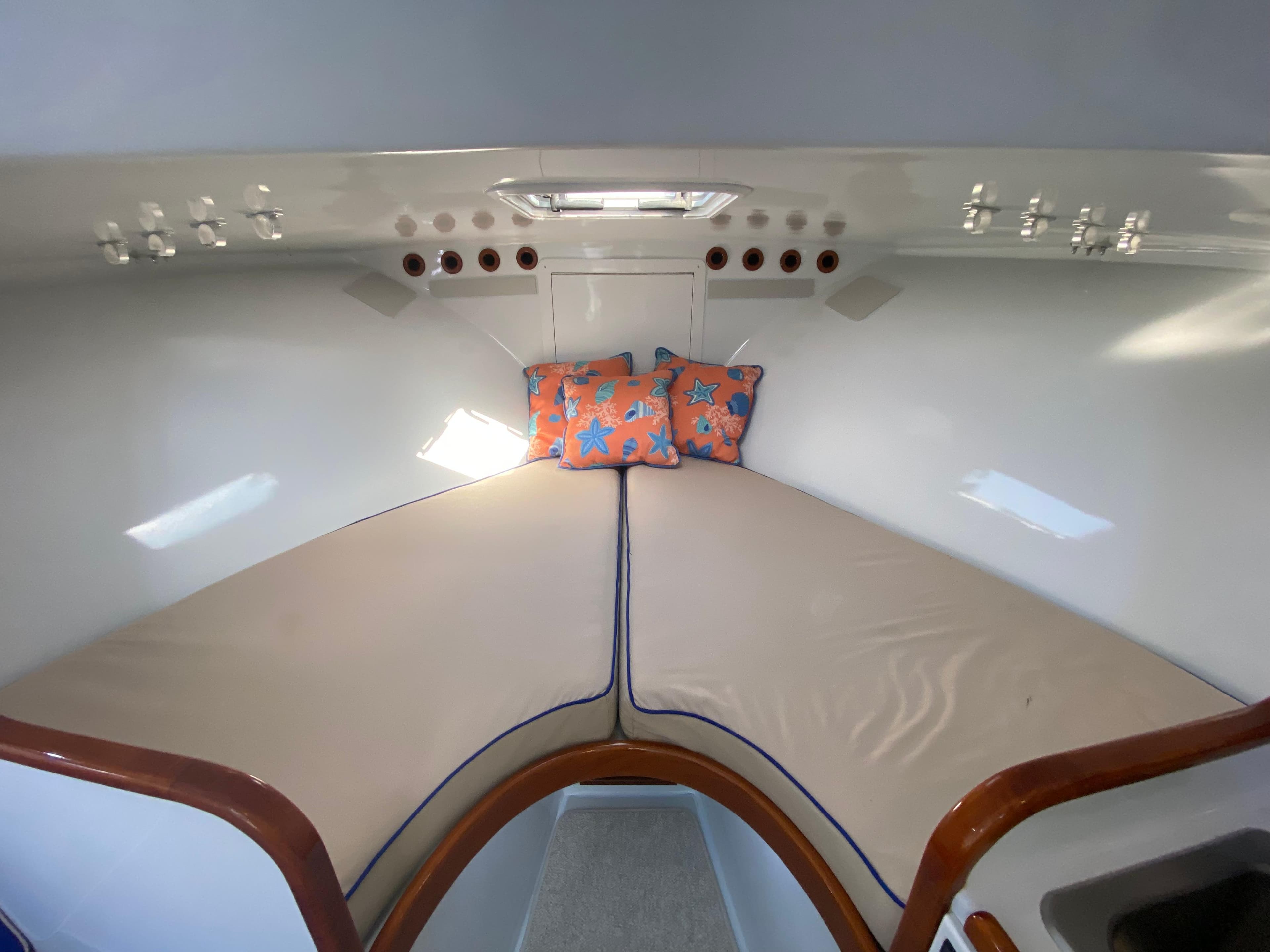 Cozy cabin interior of 1995 L&H 33 boat with starfish-patterned pillows.