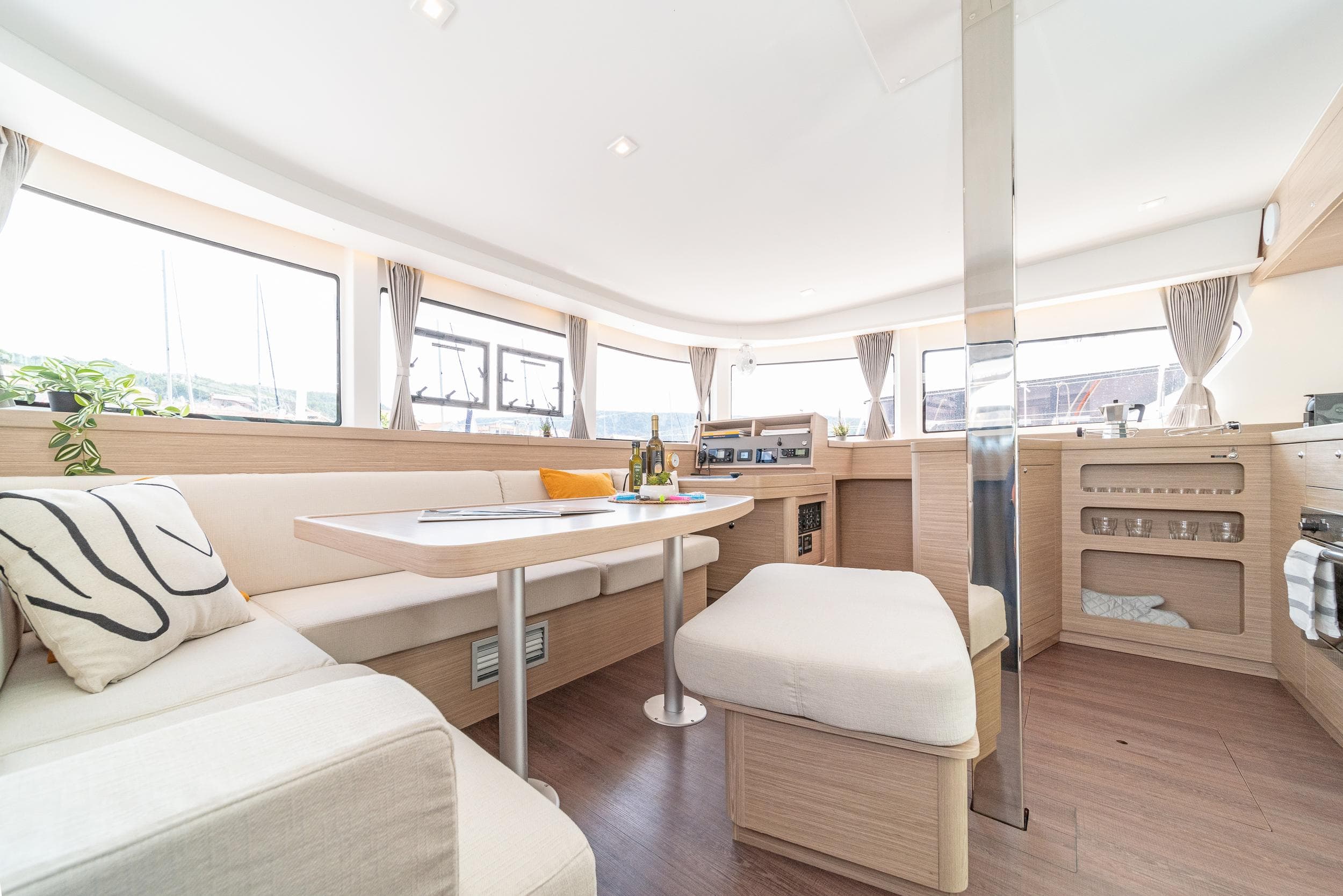 Luxurious interior of 2023 Lagoon 42 catamaran with modern seating and dining area.