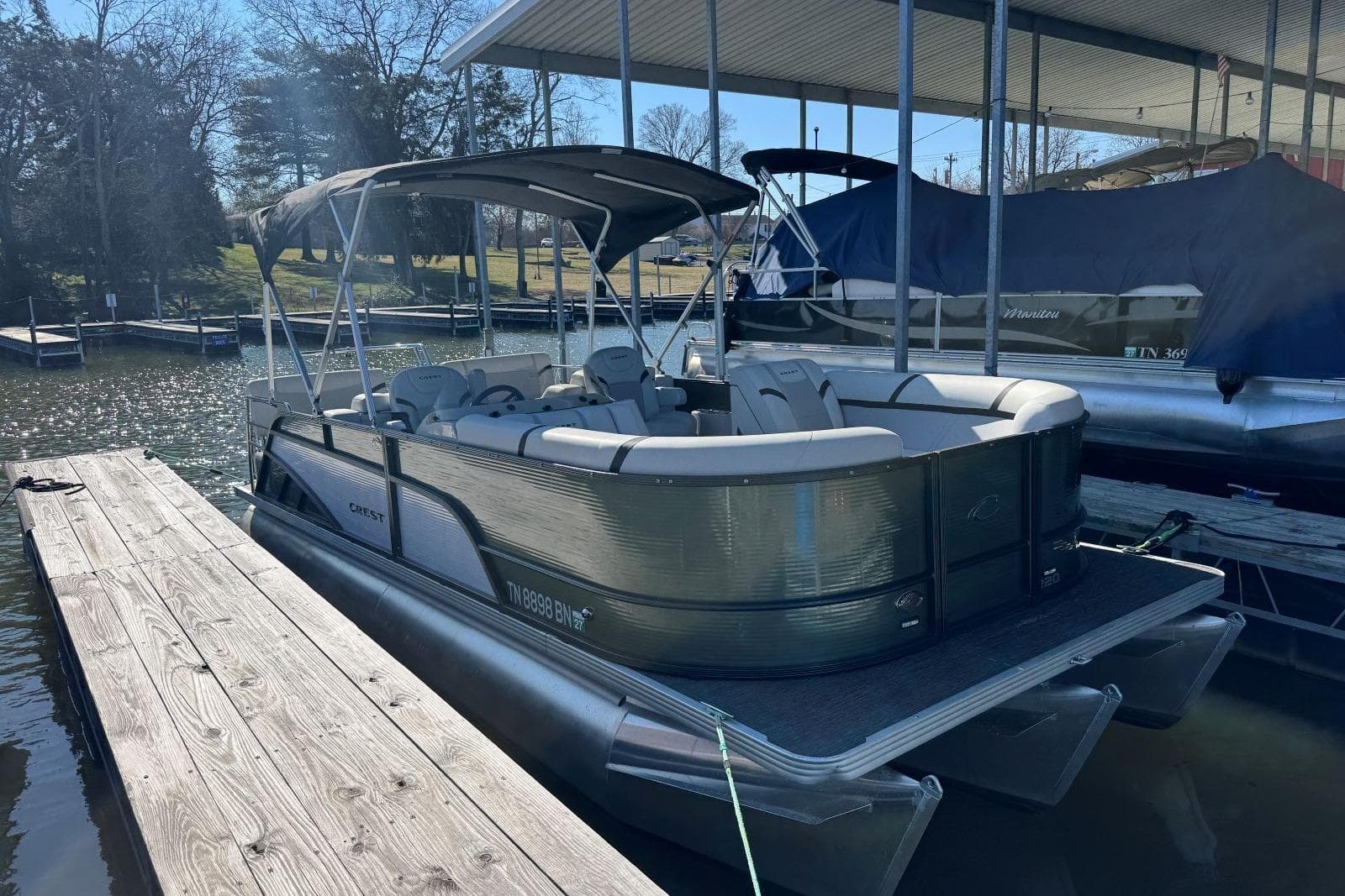 2024 Crest Classic LX 220 SLRC pontoon boat docked at a marina.