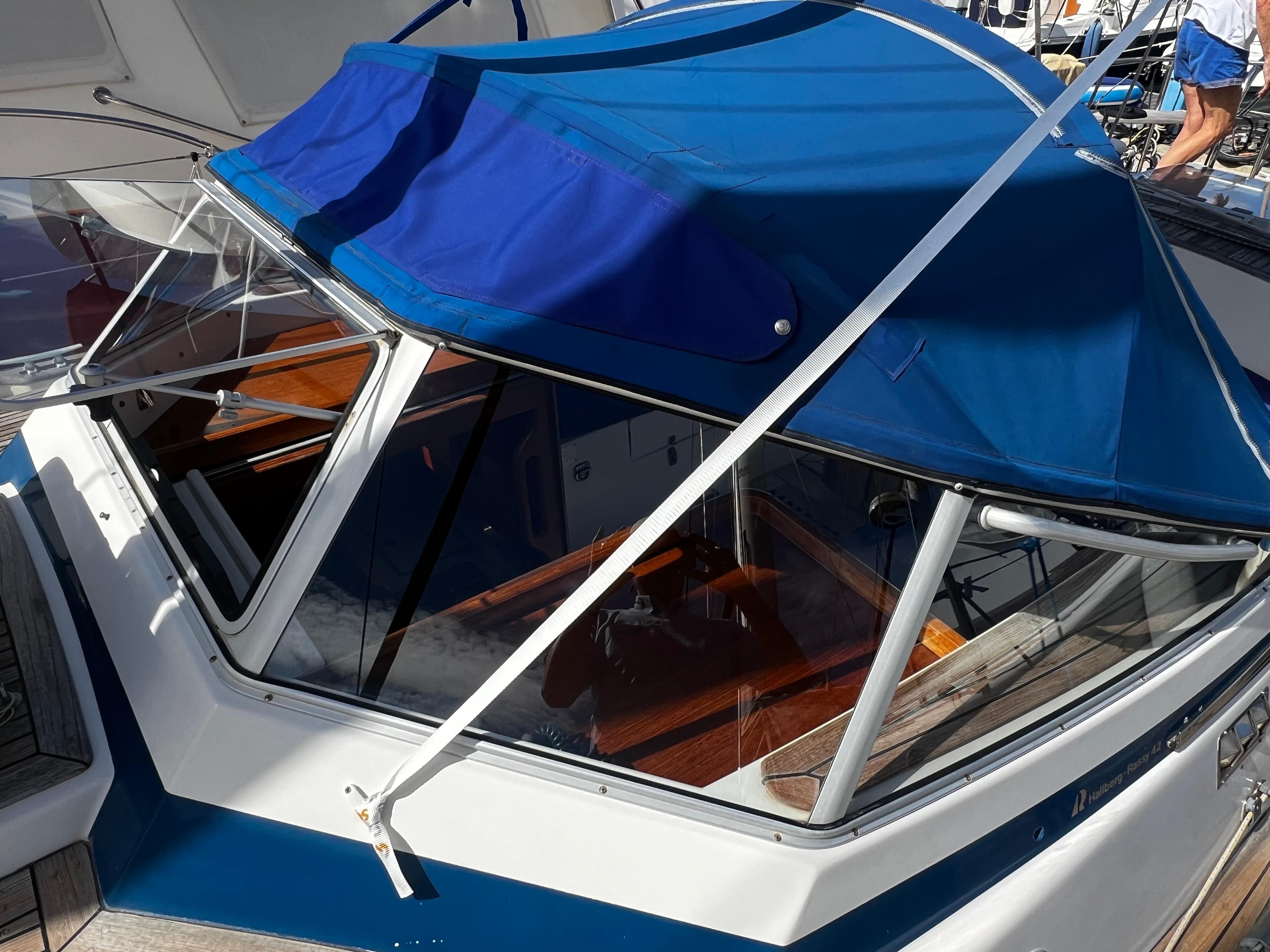 2001 Hallberg-Rassy 42 sailboat with blue canopy and wooden interior details.