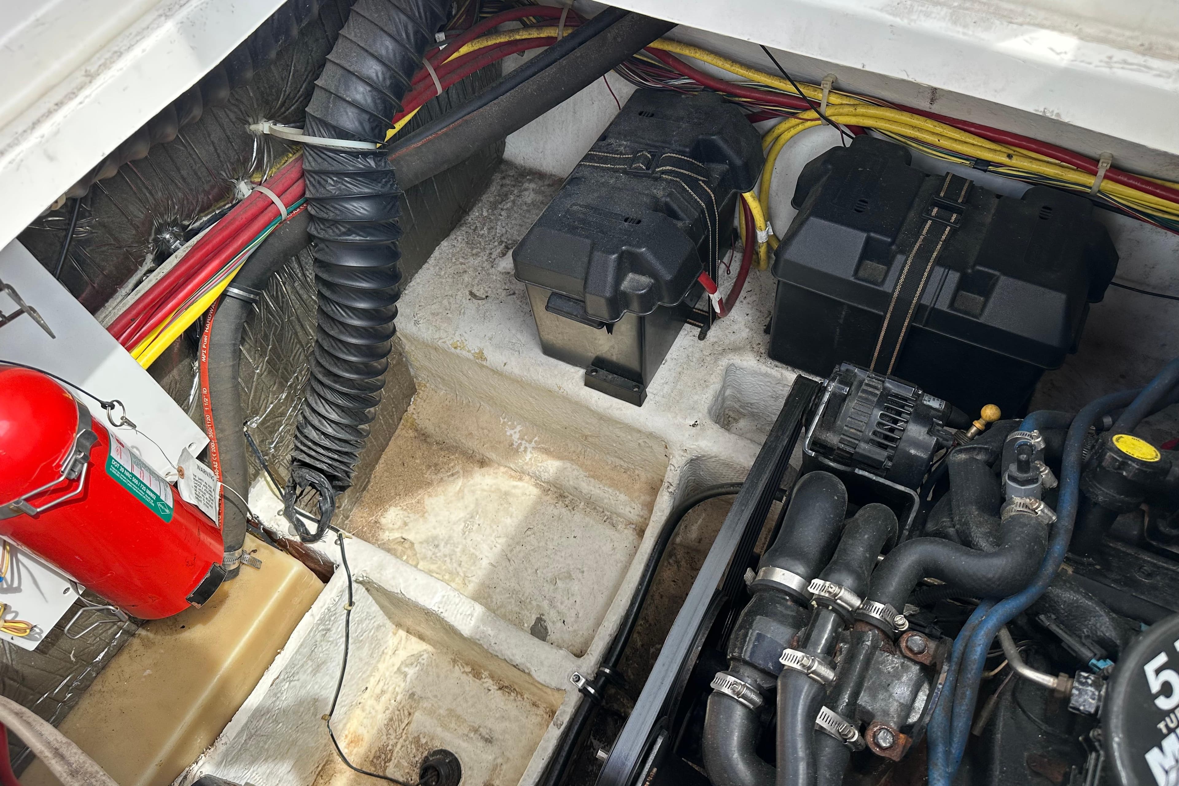 Engine compartment of a 2006 Bayliner 305 boat, featuring batteries and wiring.