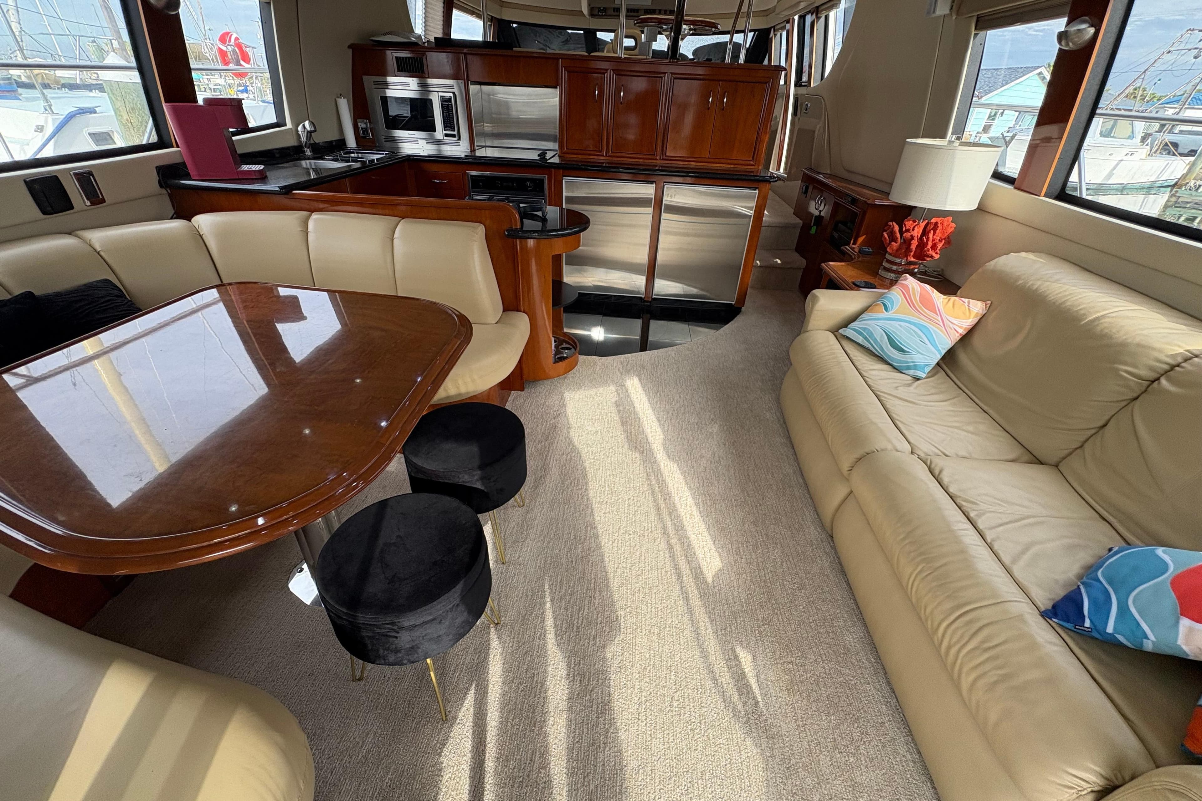 Luxurious interior of a 2004 Carver 560 Voyager yacht with elegant seating and modern kitchen.