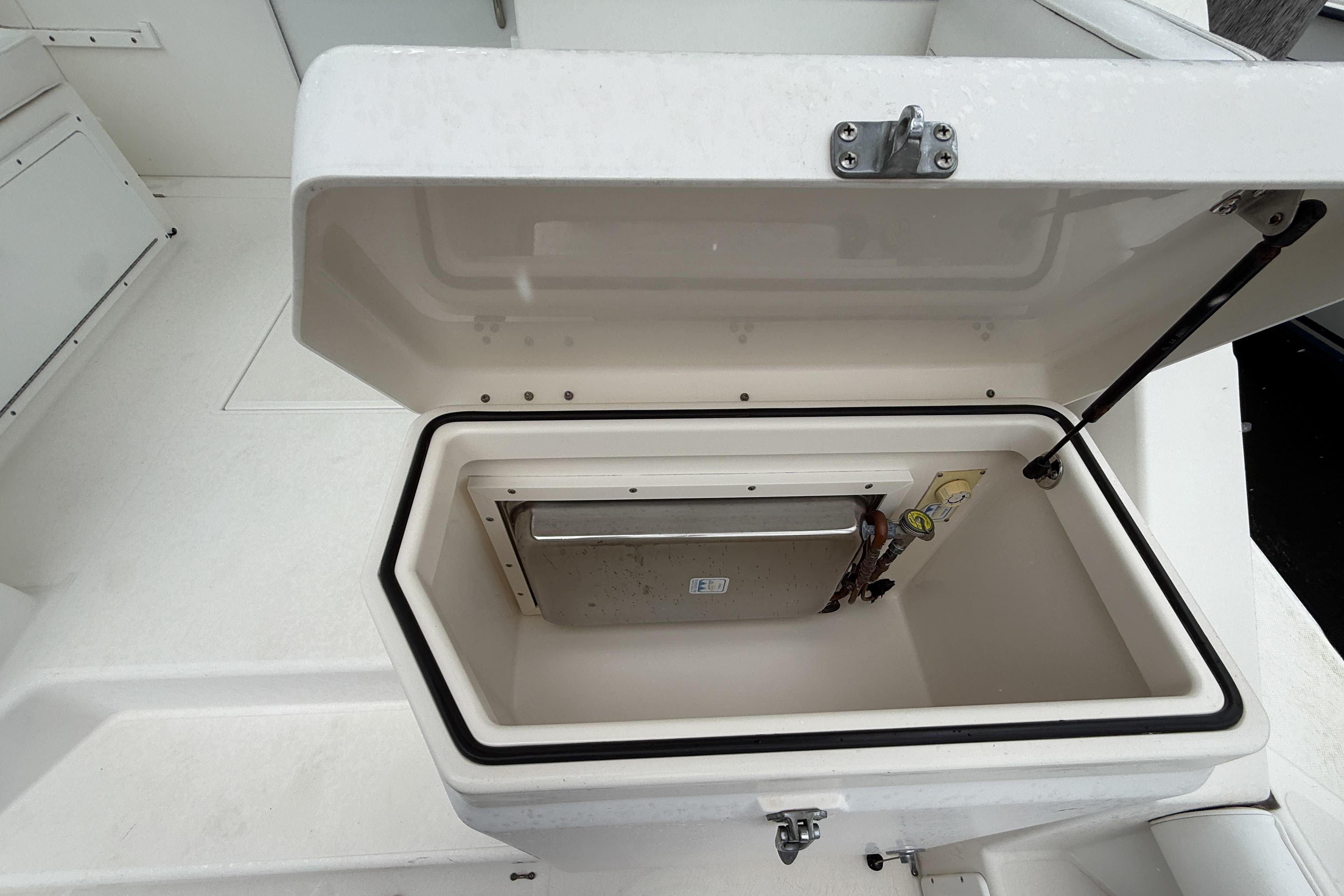 Open storage compartment on a 1998 Cabo 31 Express boat deck.
