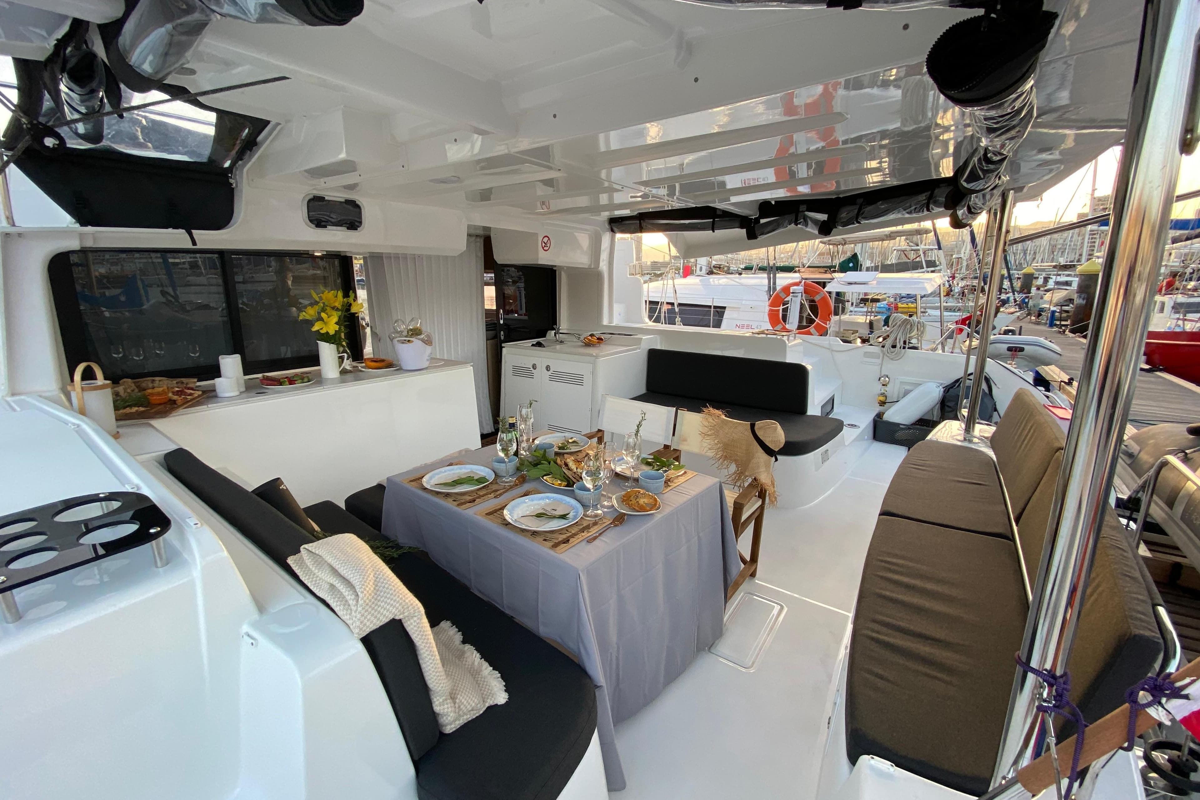 Luxurious 2023 Lagoon 46 yacht interior with elegant dining setup and comfortable seating.