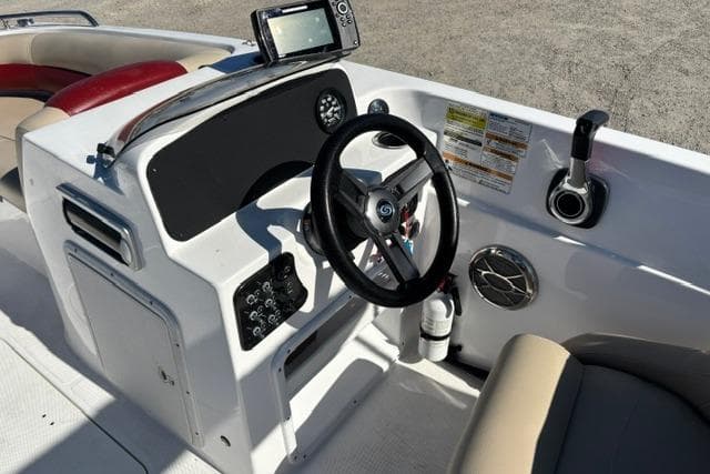 2016 Hurricane SunDeck Sport 188 OB boat dashboard with steering wheel and control panel.