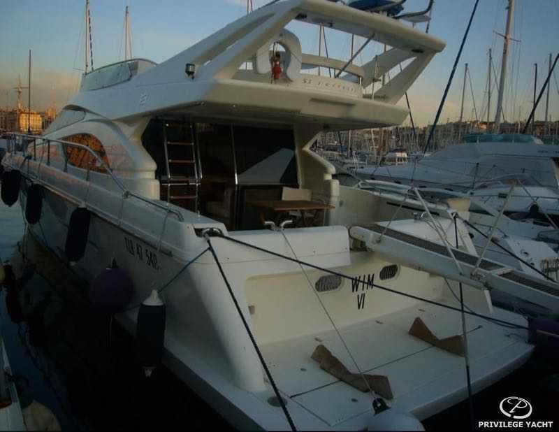 2000 Ferretti Yachts 53 docked at marina, rear view with sunset lighting.