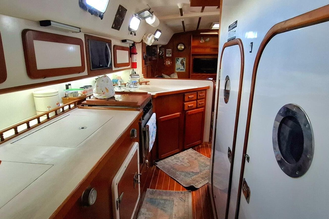 Interior of 1997 Caliber 47LRC yacht featuring a well-equipped kitchen with wooden cabinetry.