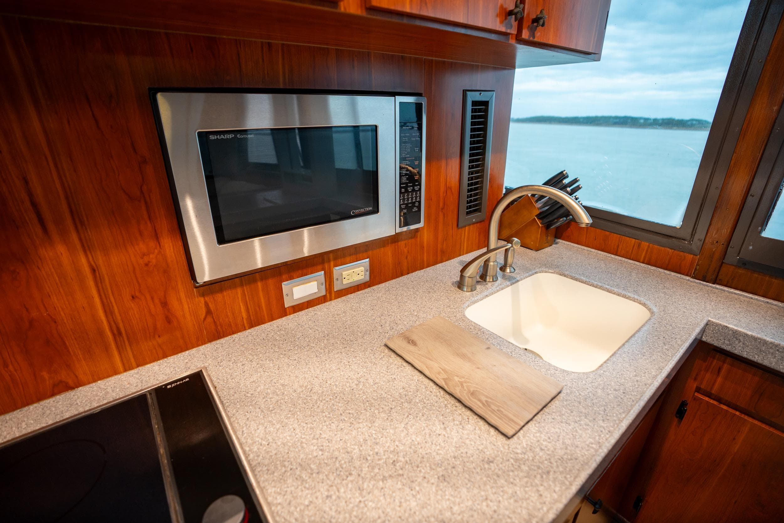 Kitchen area of 1984 Hatteras 52 Convertible yacht with sink and microwave.