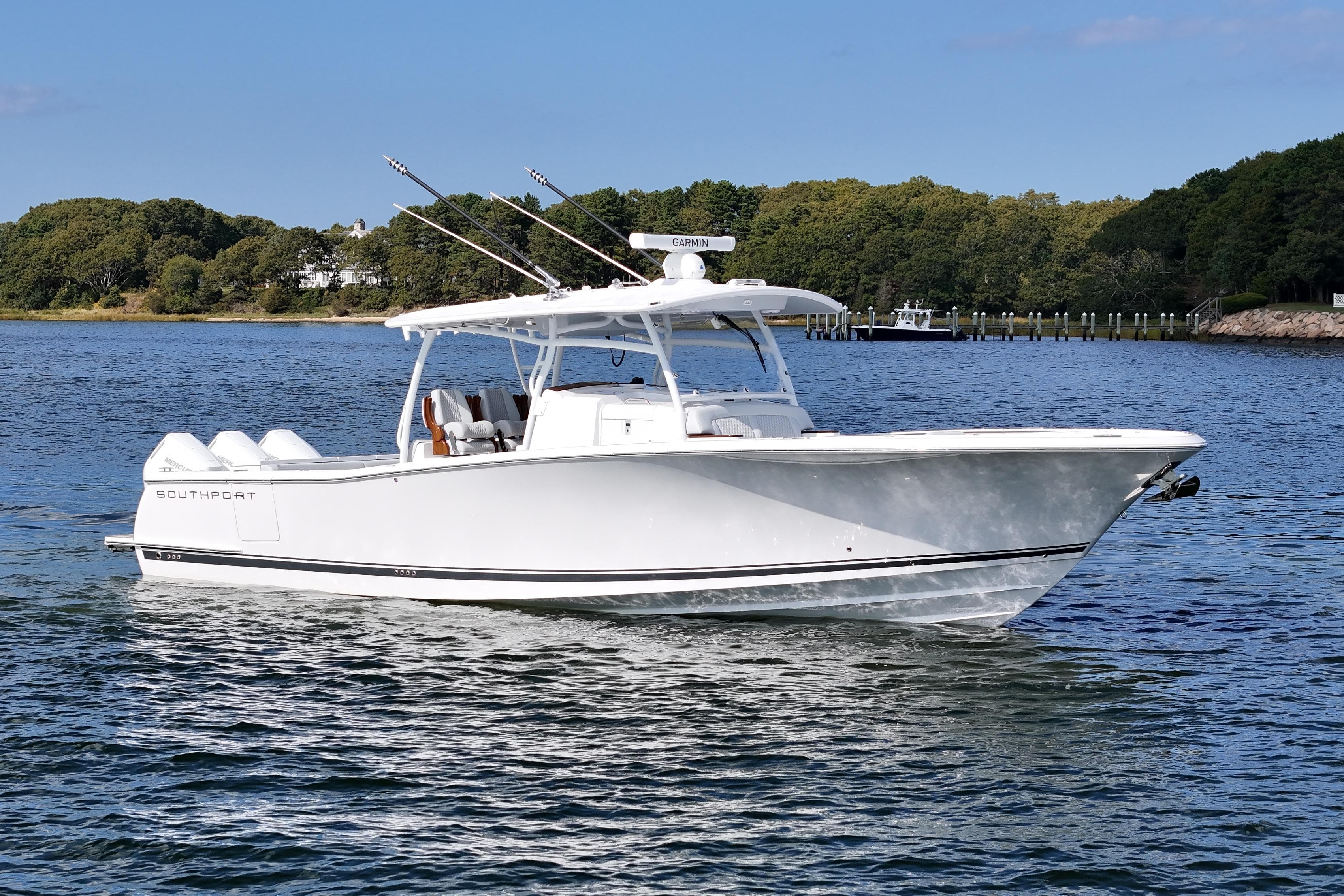 2025 Southport 38 FE boat cruising on a serene lake with lush green shoreline.