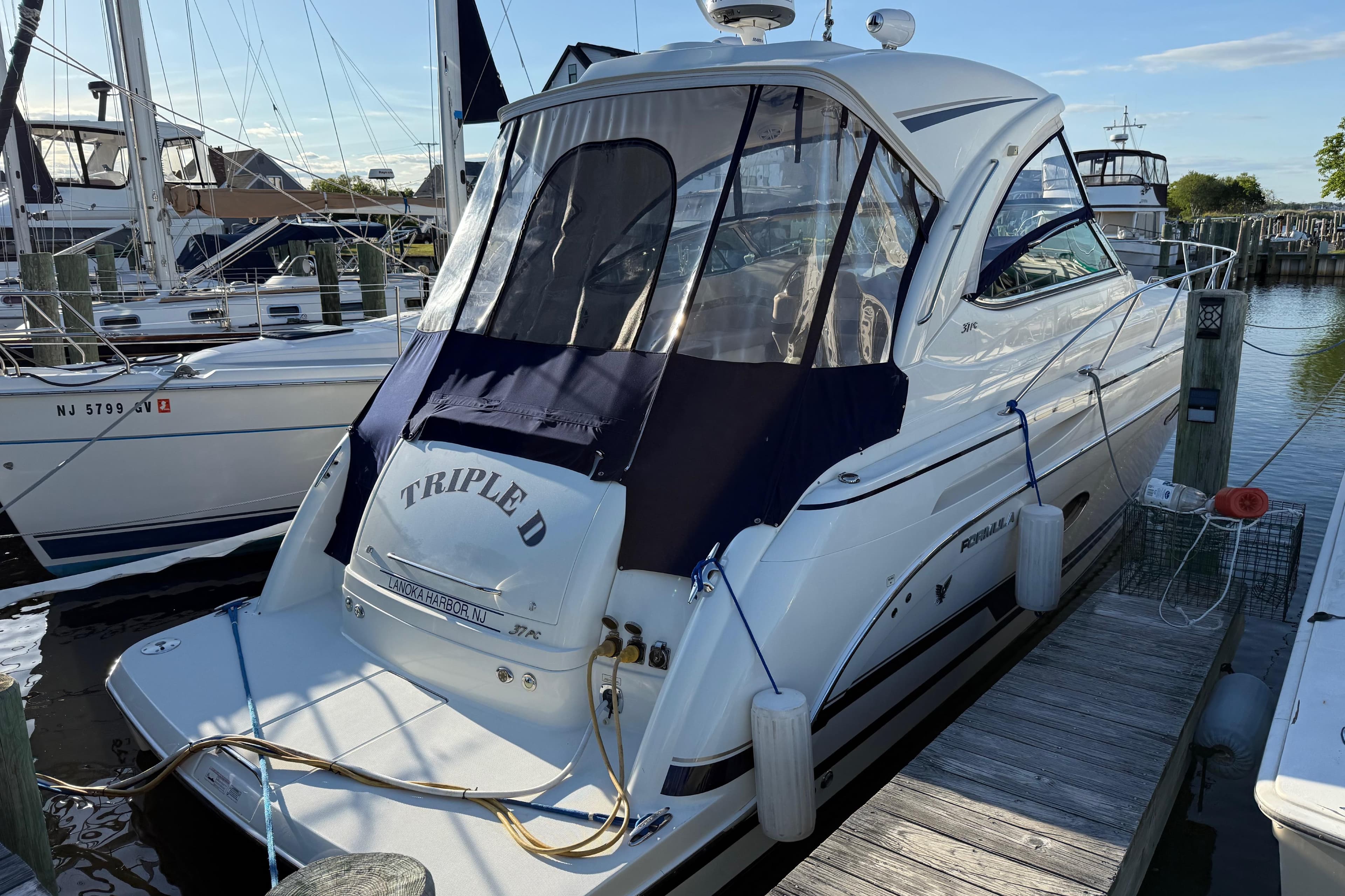 2016 Formula 37 Performance Cruiser docked at marina, featuring sleek design and navy canopy.