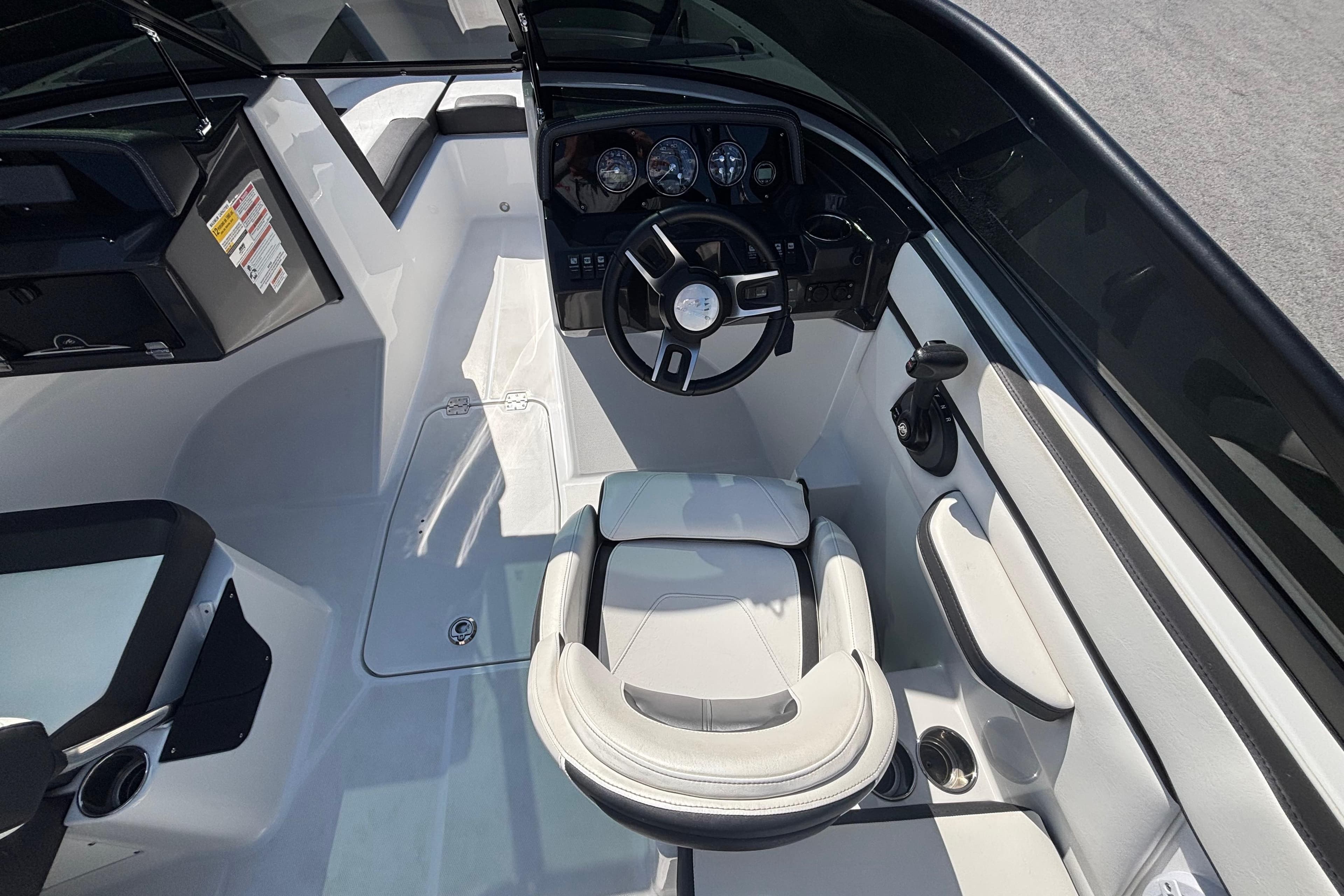 Cockpit of 2021 Monterey M-22 boat with steering wheel and seating.