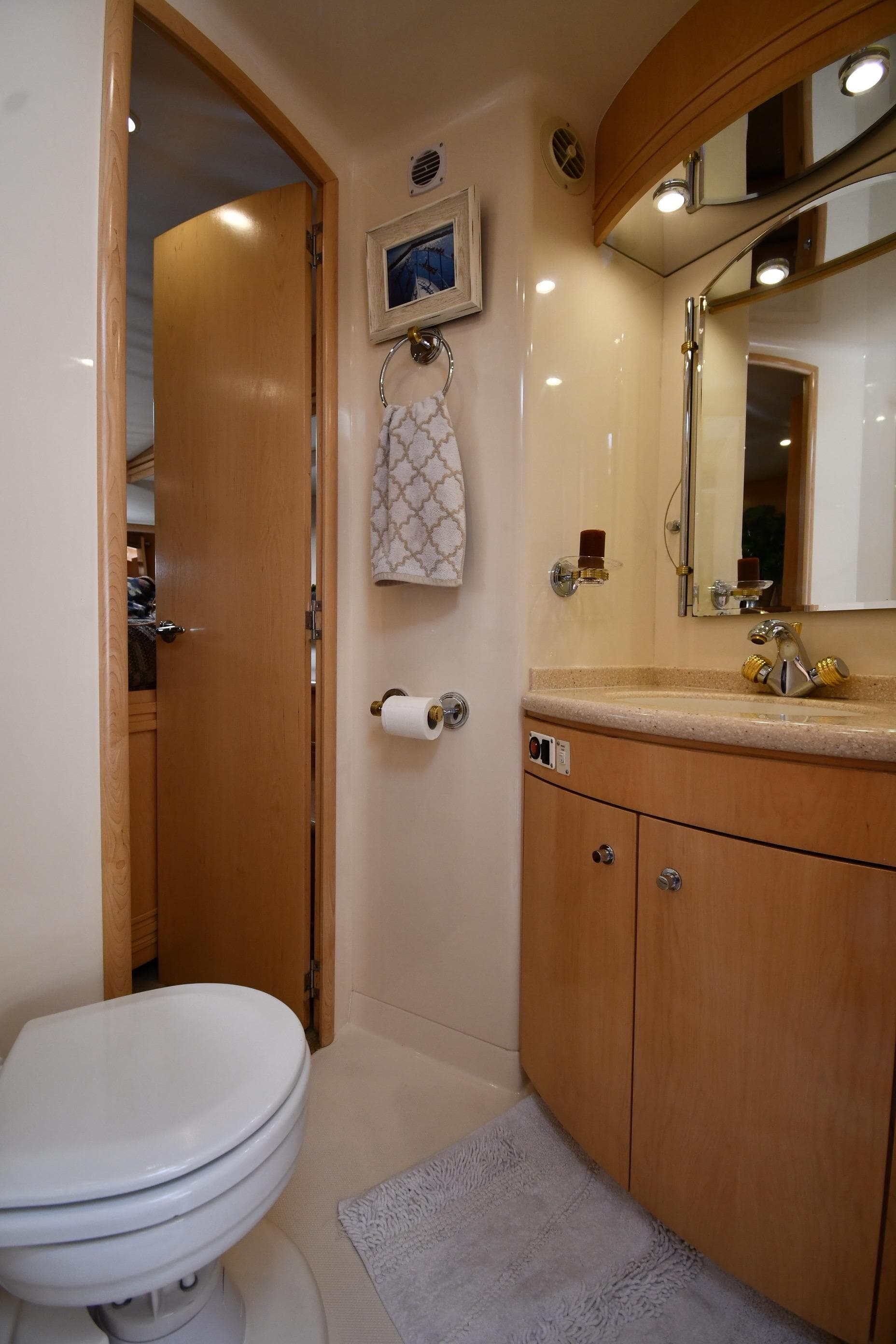 Bathroom interior of 1998 Carver 530 Voyager Pilothouse yacht, featuring modern fixtures and wood cabinetry.