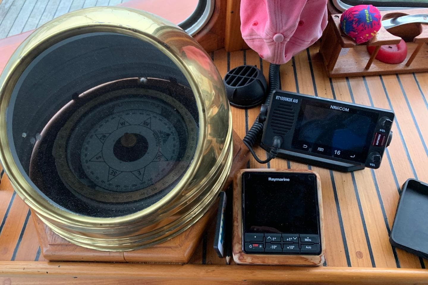 1979 Bueltjer Motorsailer navigation instruments, featuring compass and communication devices on wooden deck.