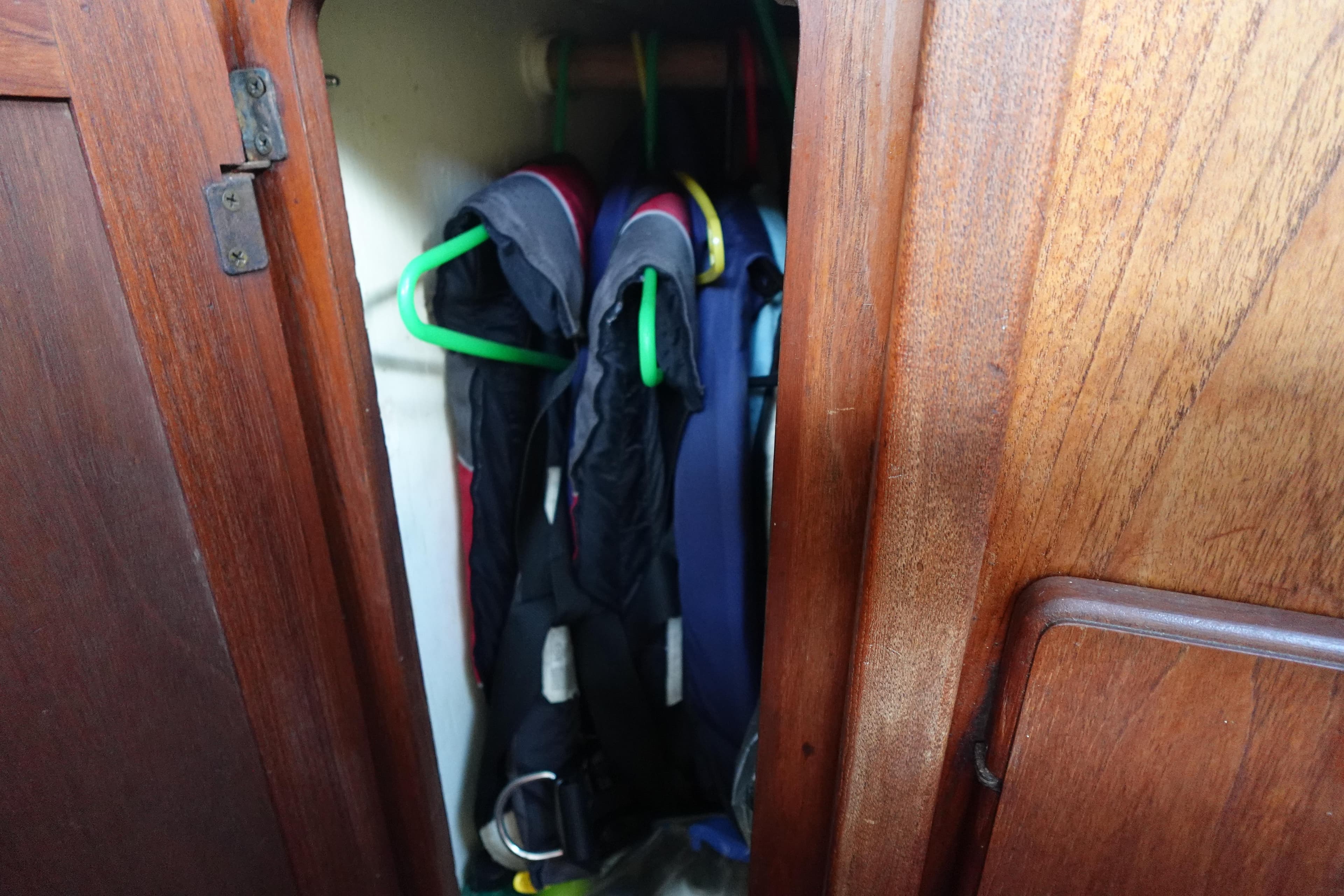 Wooden closet in 1982 Morgan 383 yacht with hanging jackets.