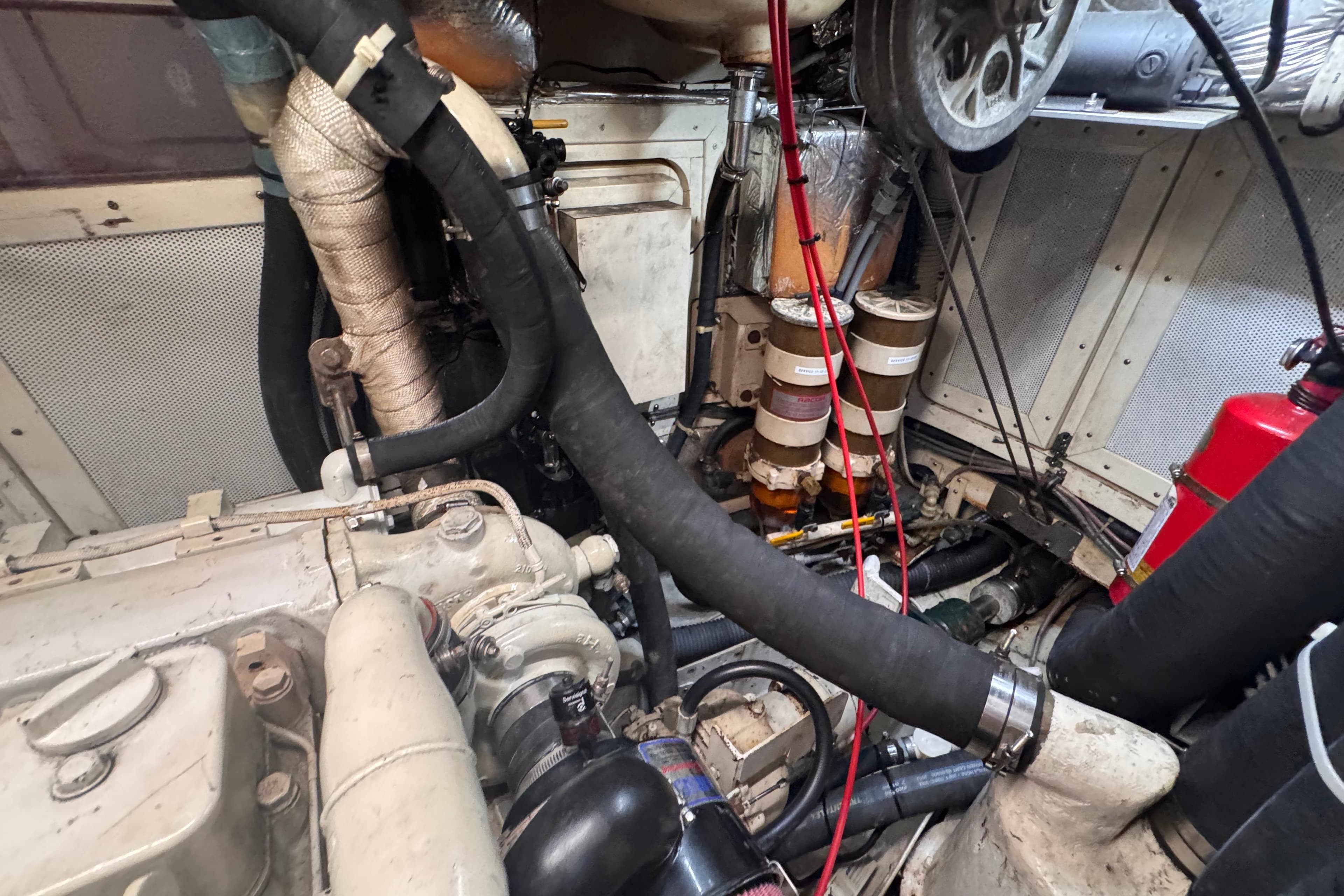 Engine room of a 1989 Little Harbor Sloop 58' with visible components and hoses.