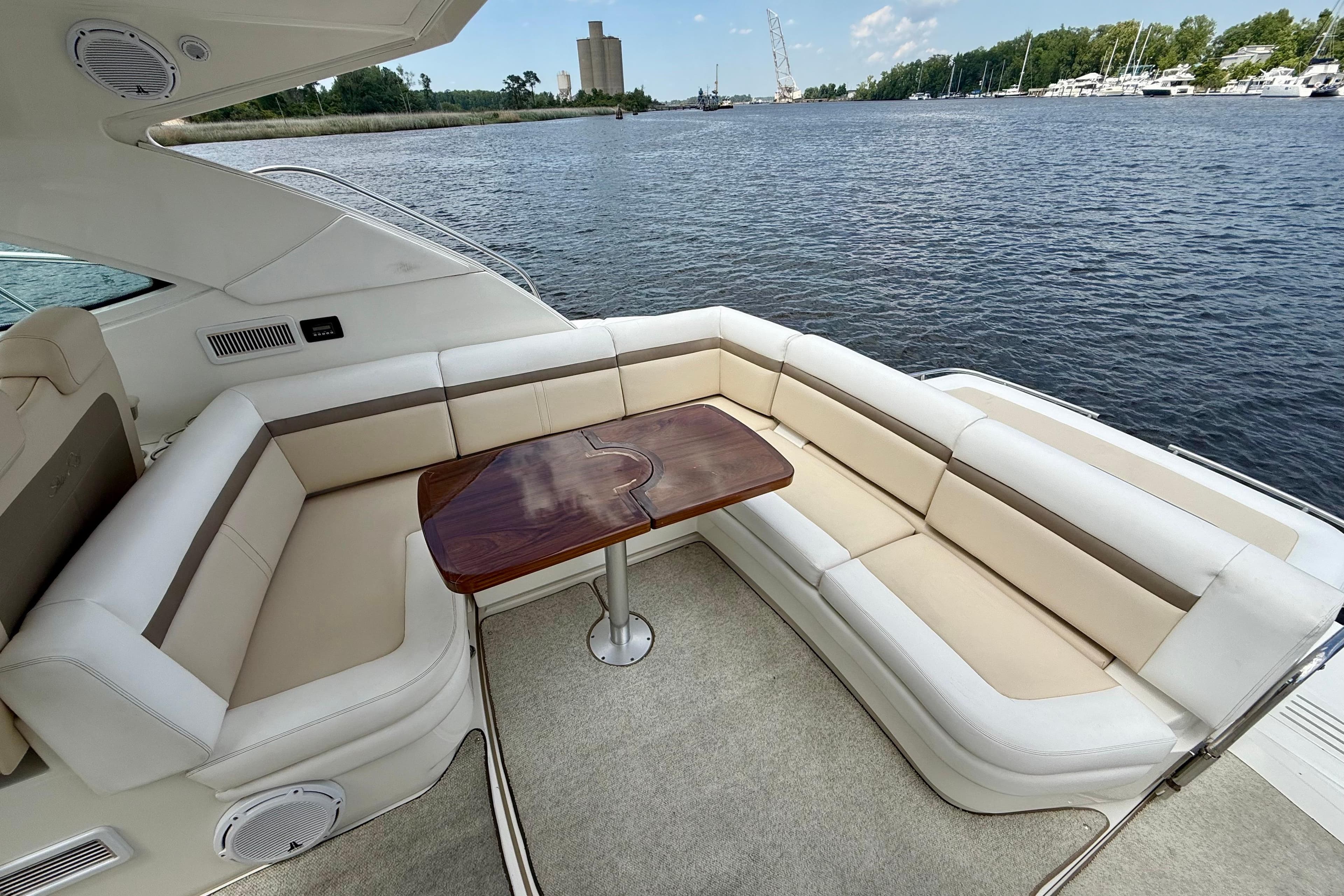 Luxurious seating area on 2012 Sea Ray 410 Sundancer yacht by the water.