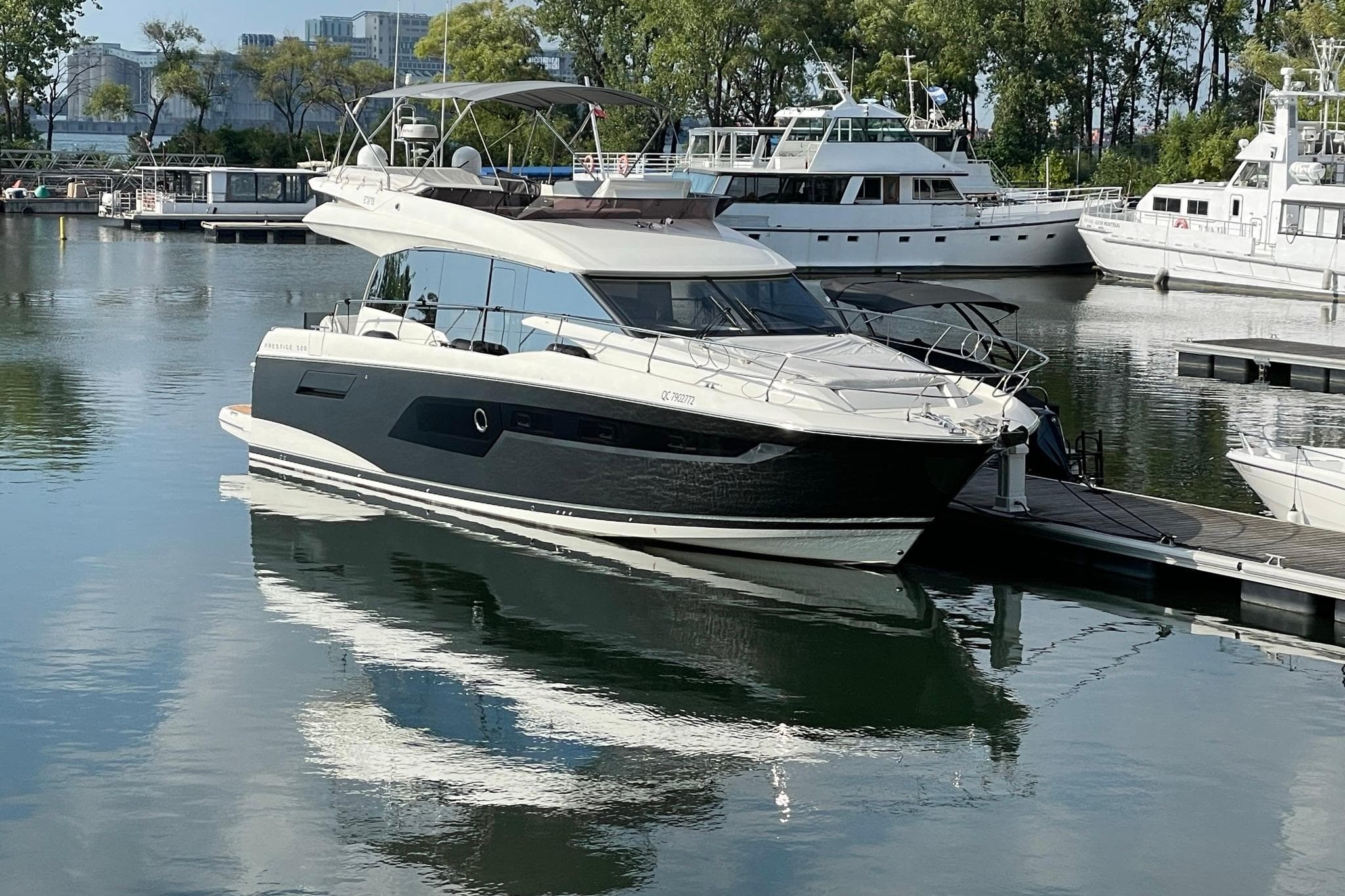 Luxury 2022 Prestige 520 yacht docked in a serene marina setting.