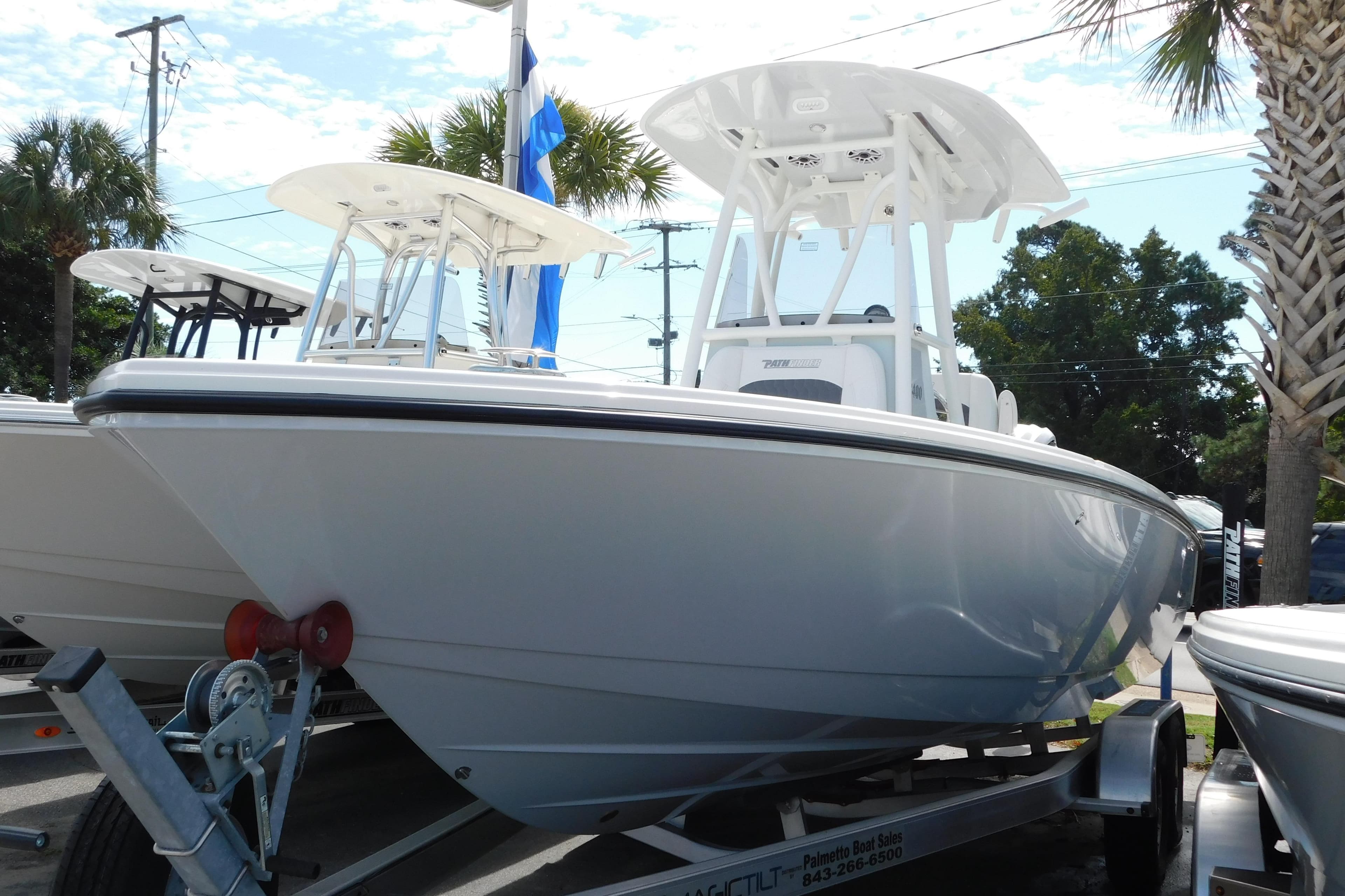 2026 Pathfinder 2400 TRS boat on trailer, displayed outdoors with palm trees.