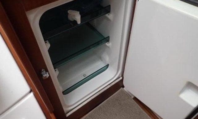 Beneteau Oceanis Clipper 361 (2002) interior fridge with open door and glass shelves.