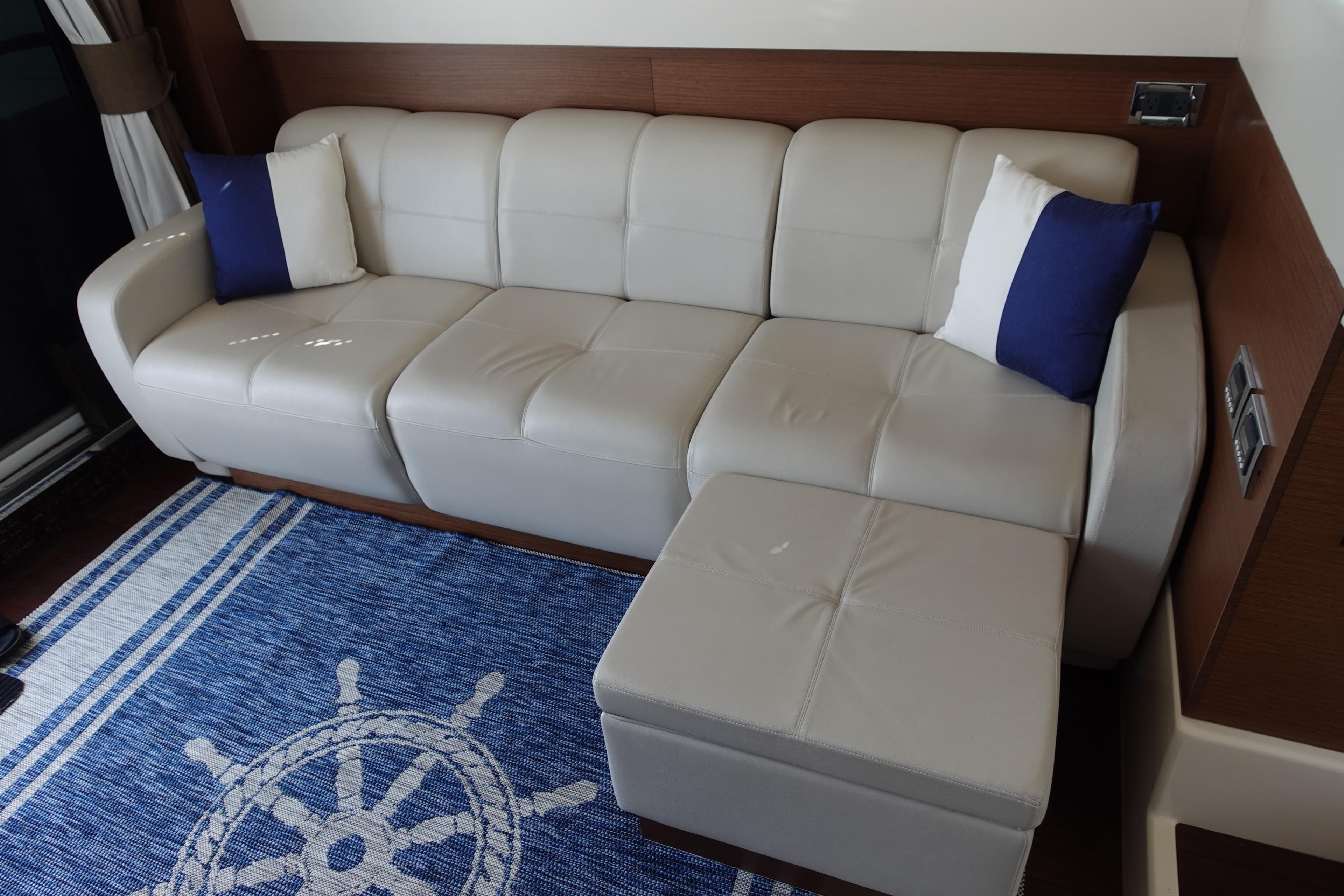 Luxurious white leather sofa on Sea Ray 450 Sedan Bridge, 2012, with nautical-themed decor.