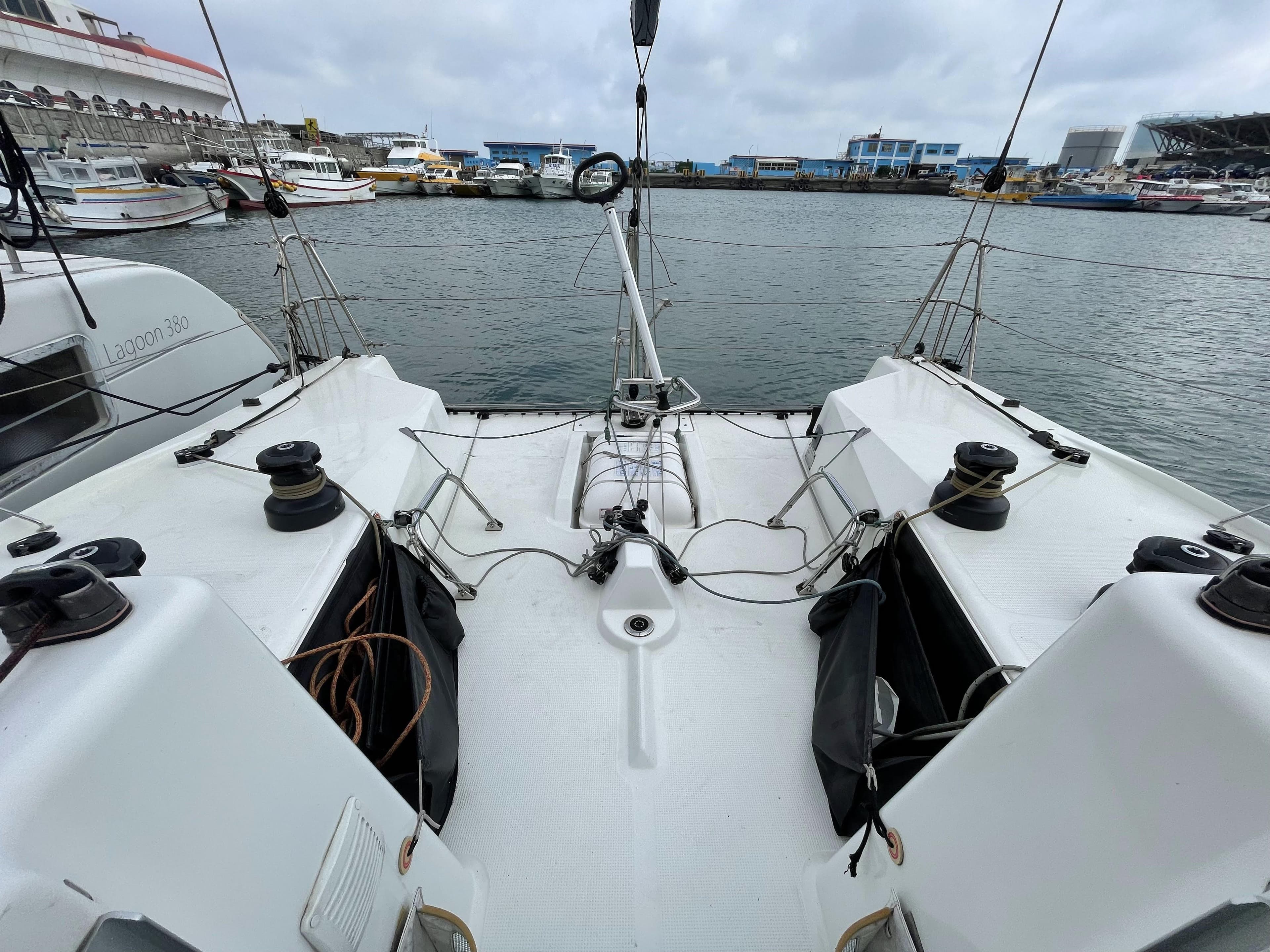 Beneteau Figaro 3 sailboat cockpit, 2018 model, docked in a marina with overcast skies.
