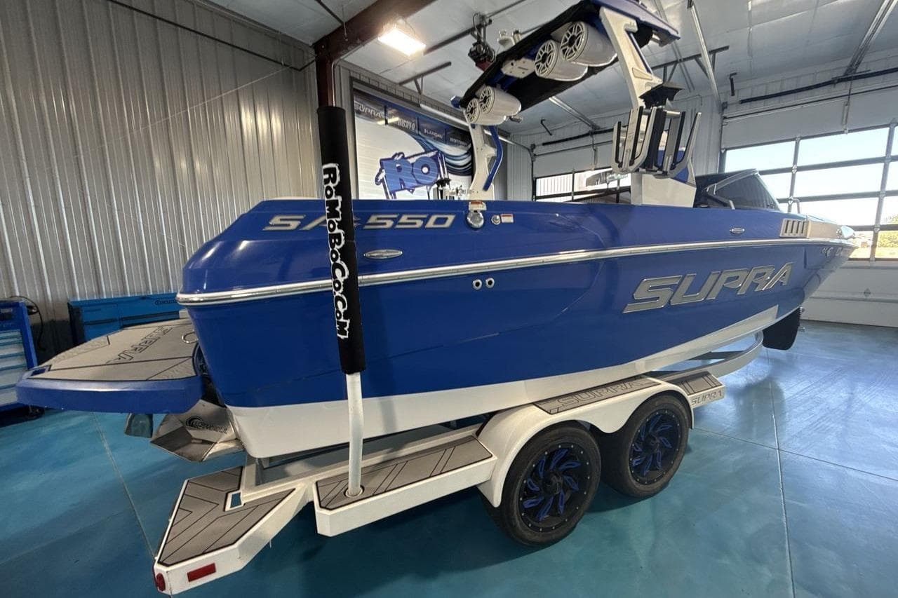 2019 Supra SA 550 boat in a garage, blue exterior, on a trailer.