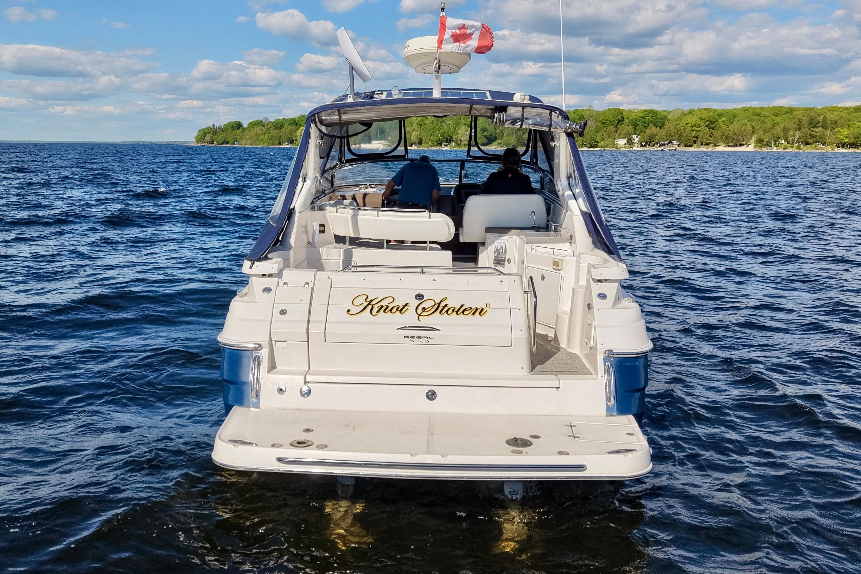 2006 Regal Commodore 3560 IO boat on water, rear view with Canadian flag.