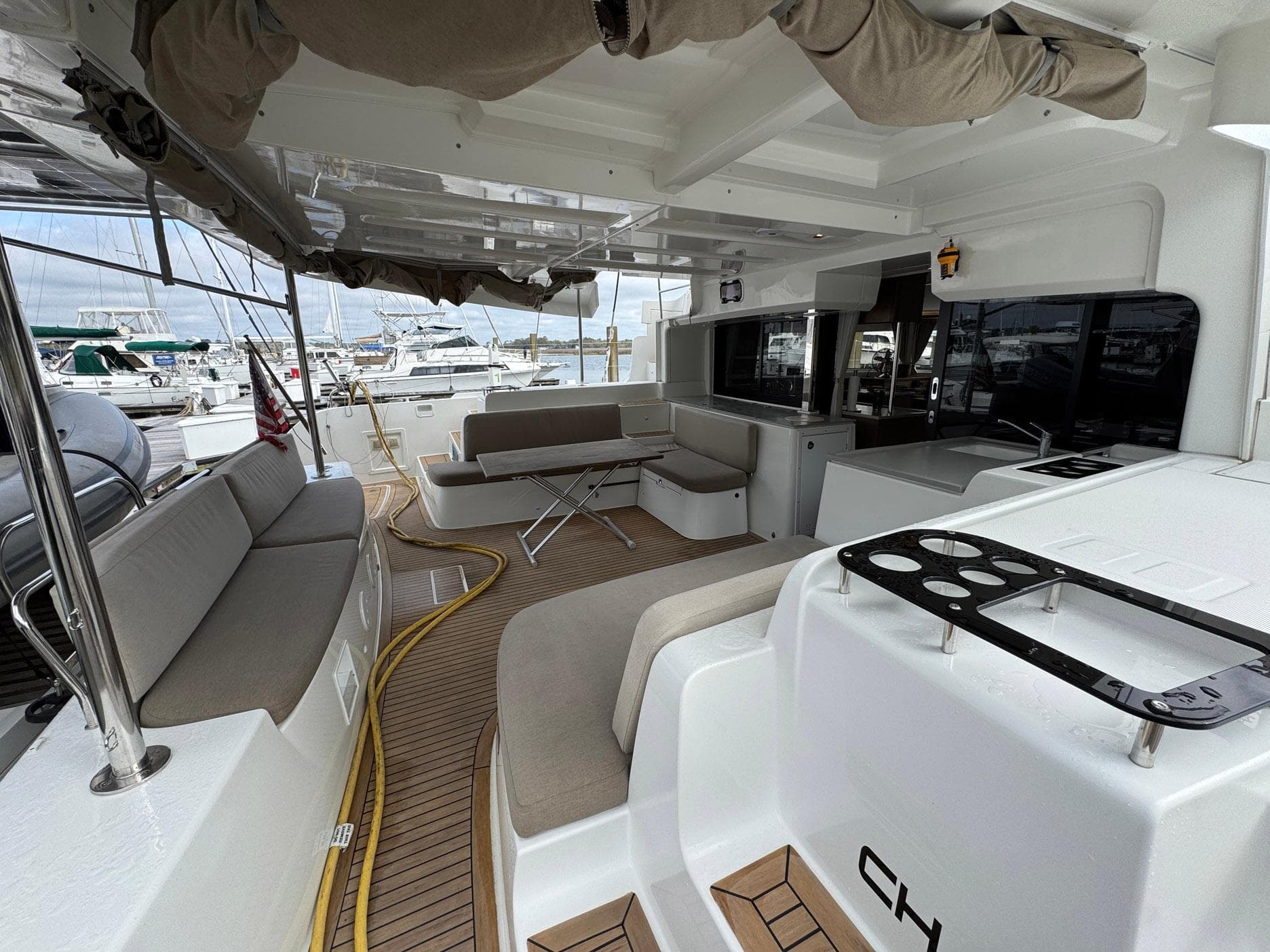 Spacious deck of 2022 Lagoon 46 catamaran with seating and marina view.