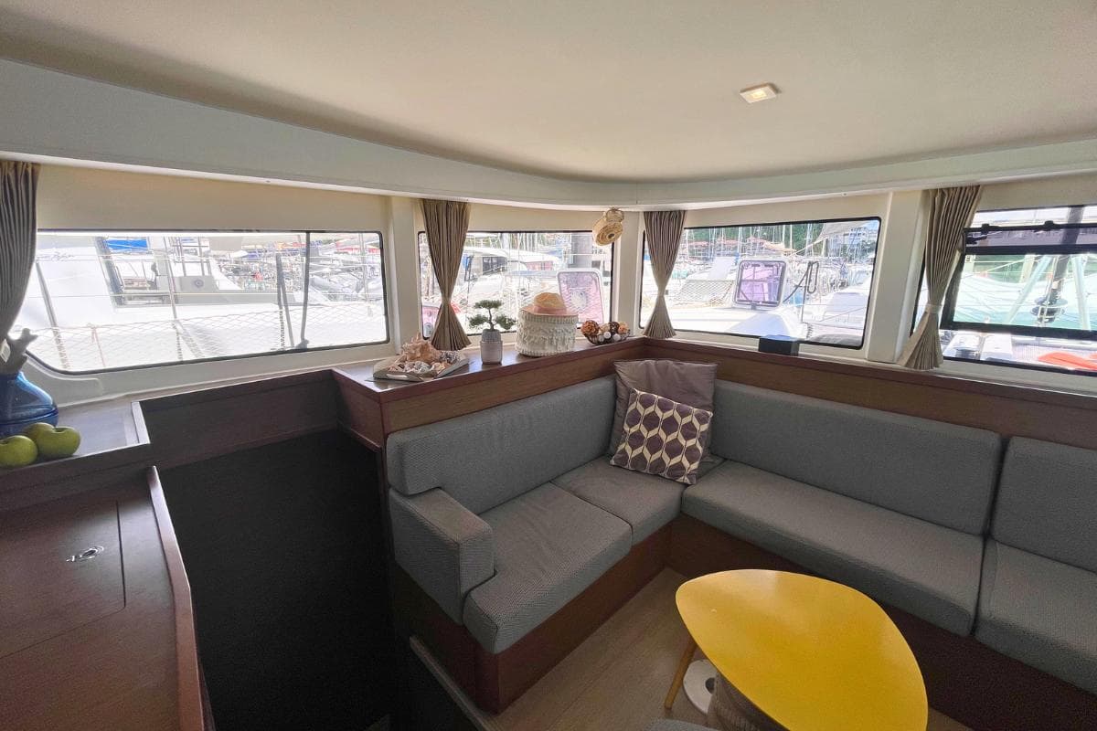 Interior of 2018 Lagoon 42 catamaran with cozy seating and large windows.