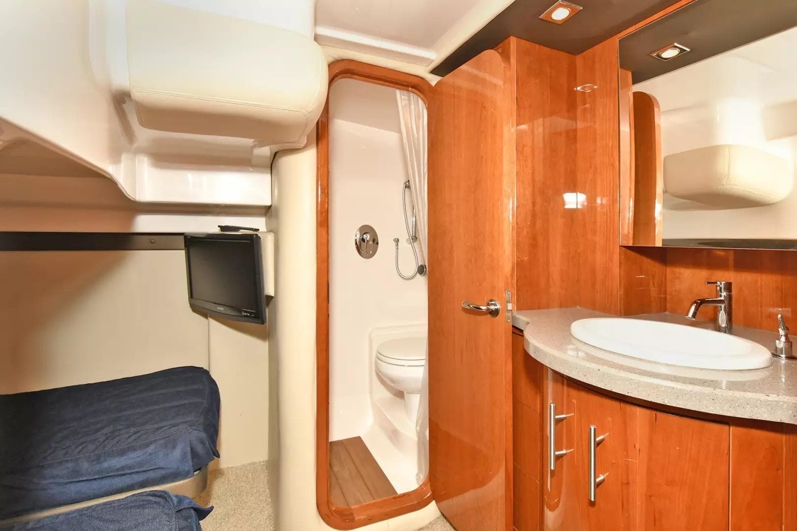 Luxurious interior of 2012 Regal 42 Sport Coupe yacht with bathroom and cozy sleeping area.