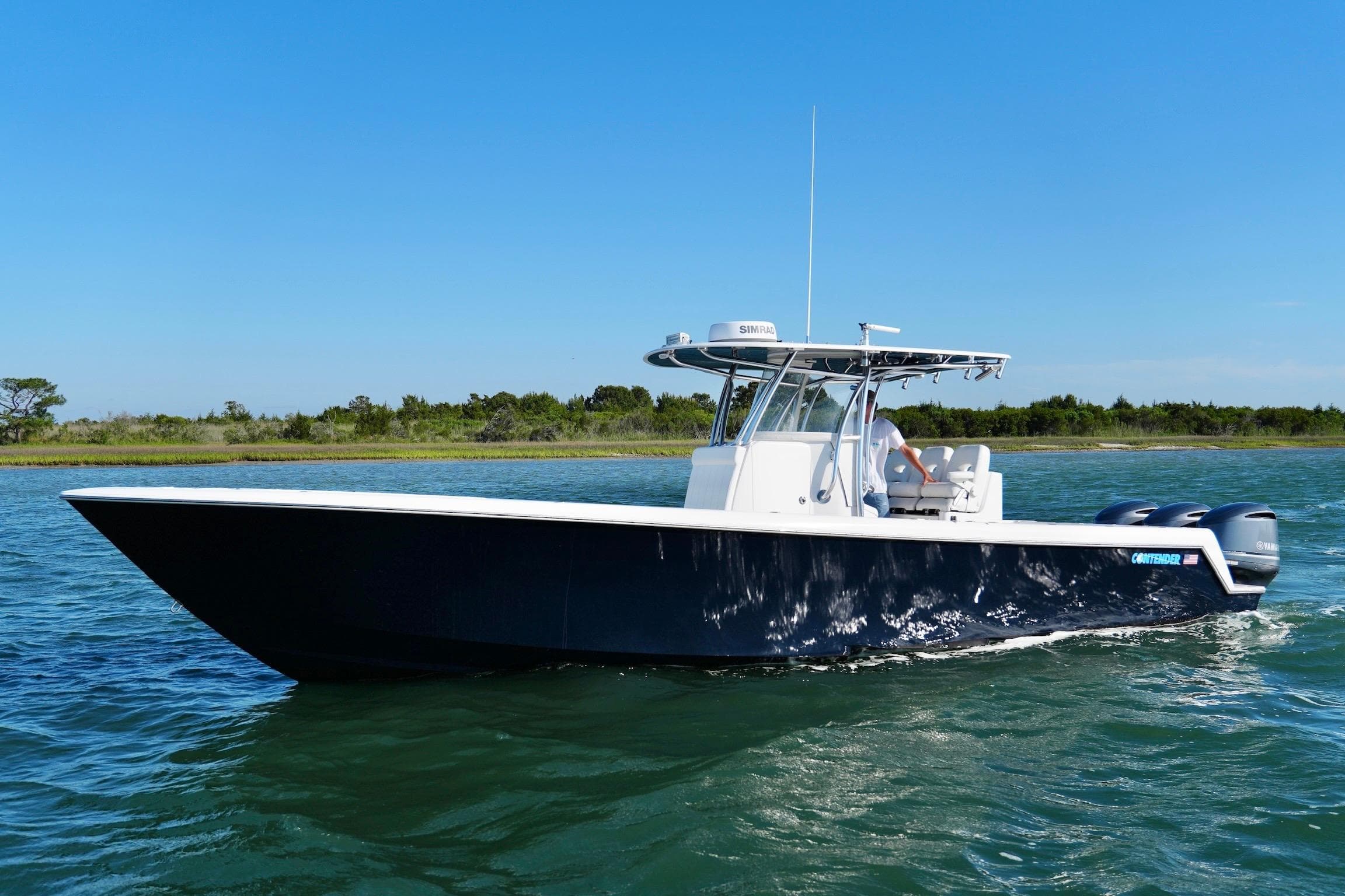 2019 Contender 35 ST boat cruising on clear blue water under a sunny sky.