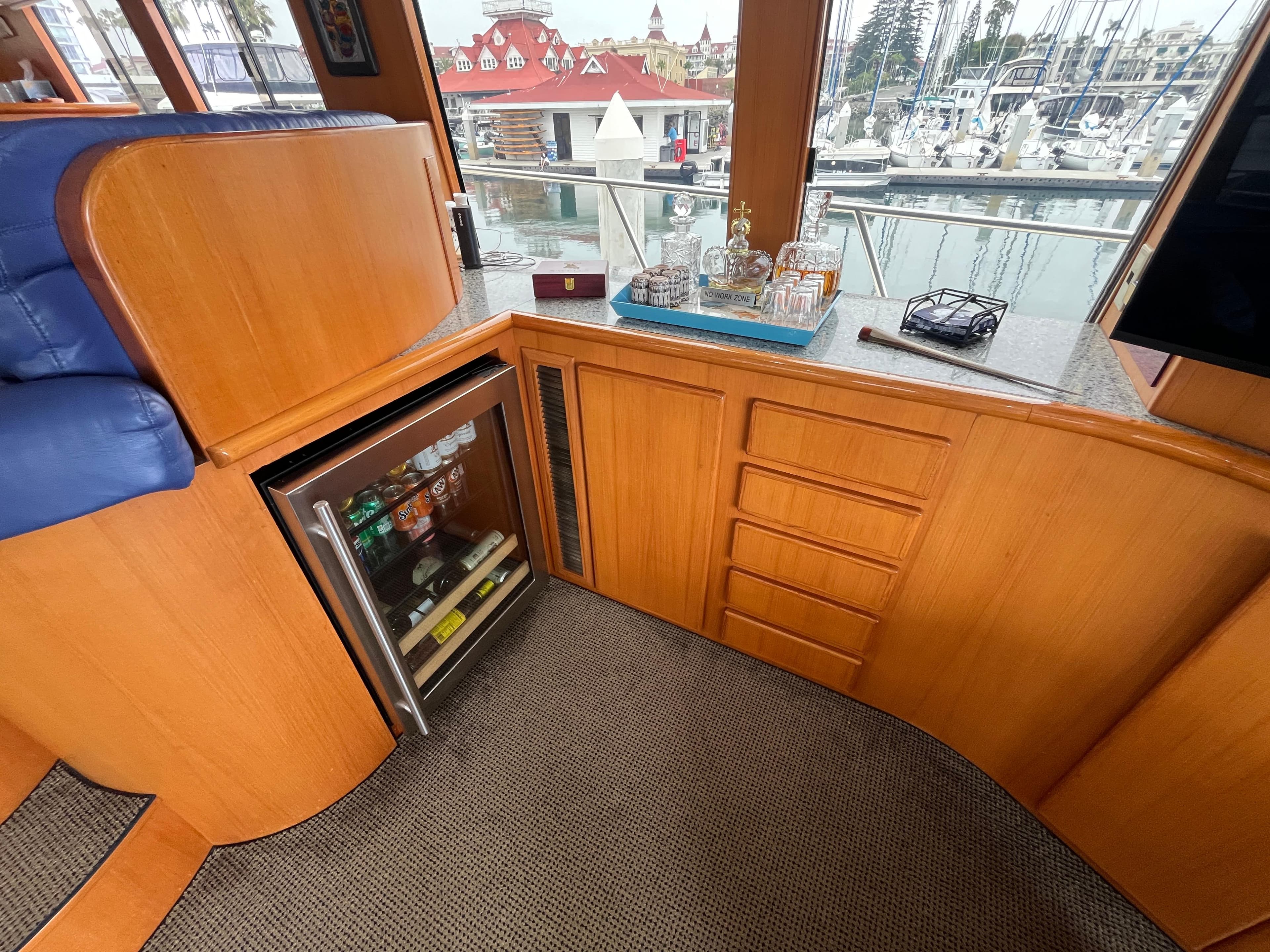 1999 Mikelson Long-Range Luxury Sportfisher interior with minibar and marina view.