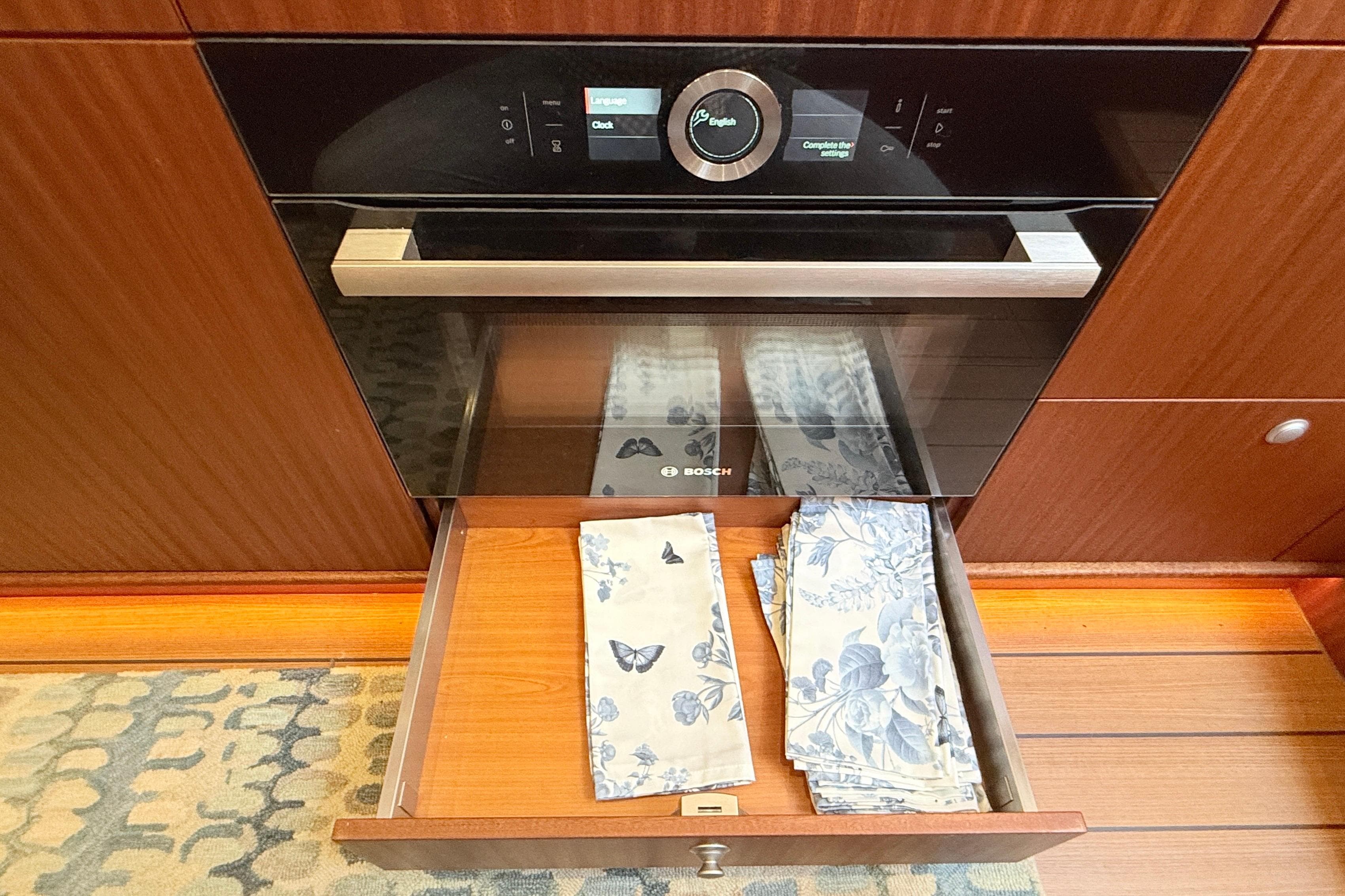 Modern Bosch oven in Elling E6 yacht kitchen, 2021, with floral napkins in drawer.