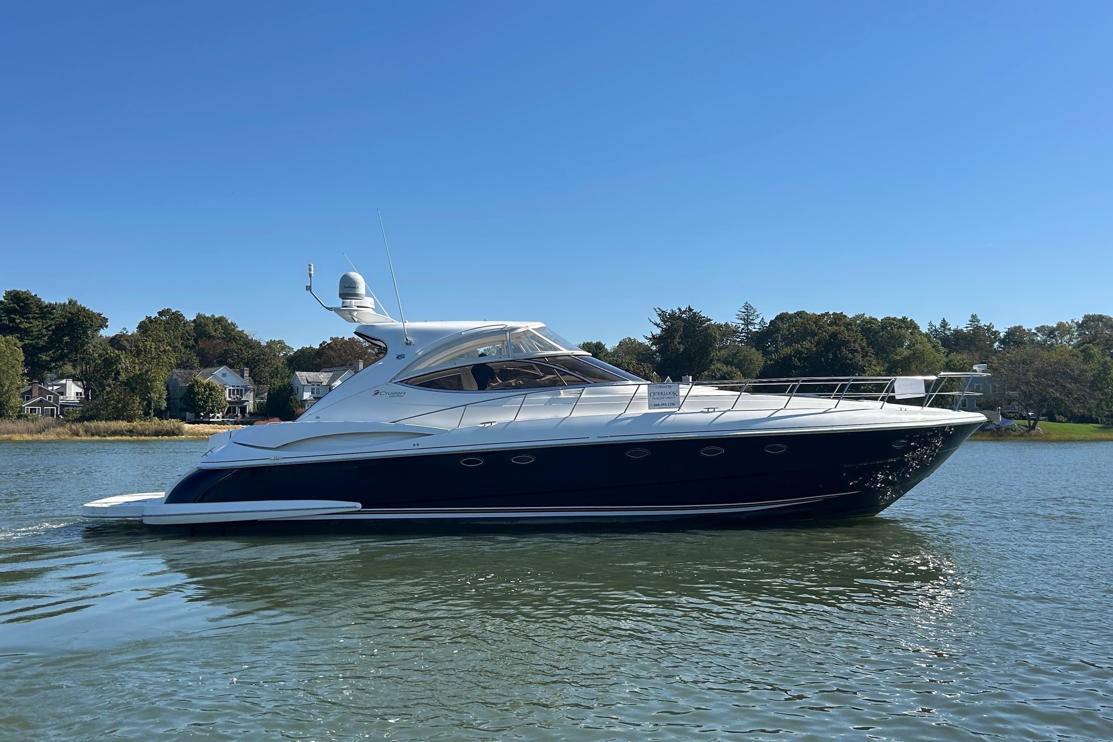 2003 Cruisers Yachts 540 Express on calm water, surrounded by trees and houses.