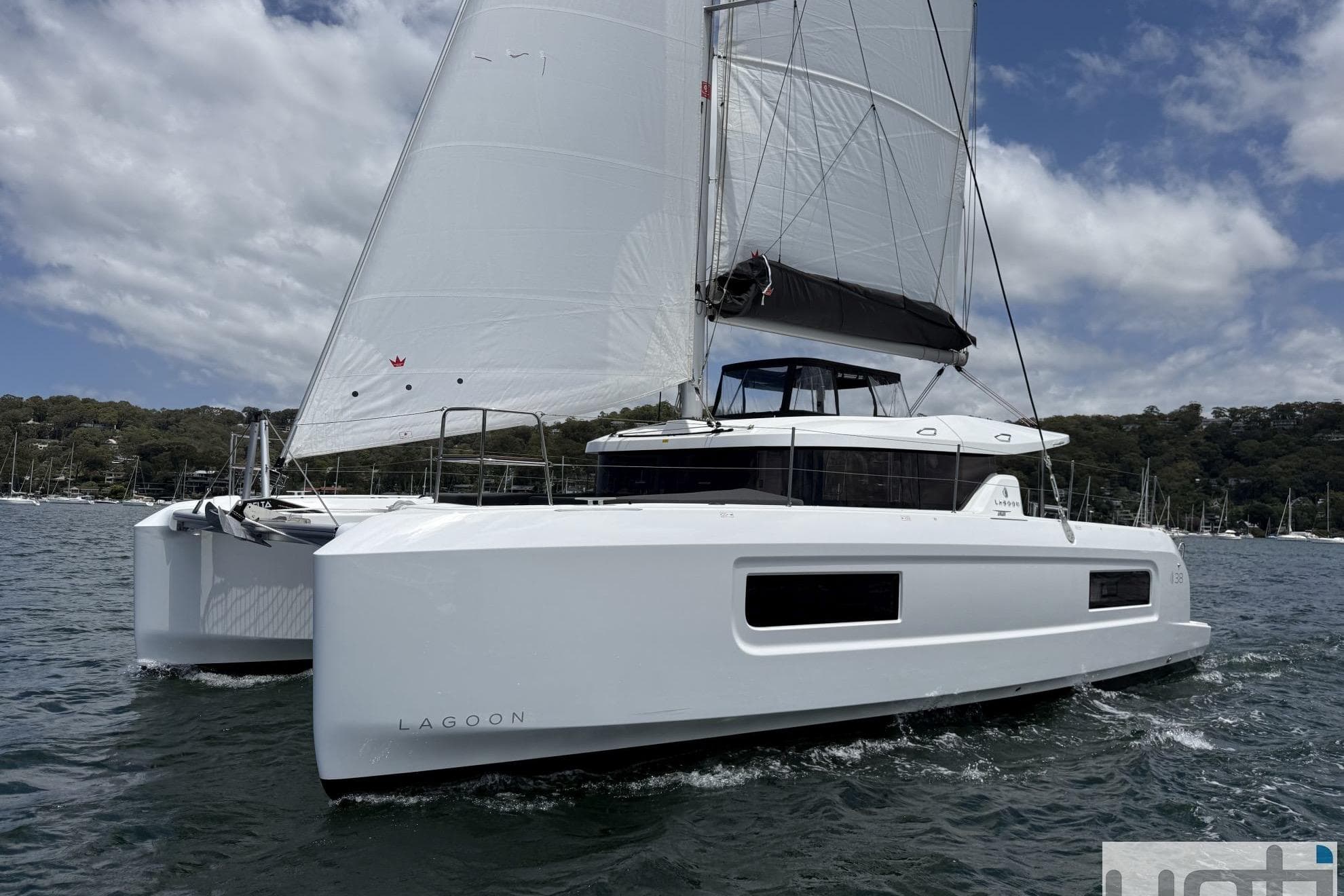2026 Lagoon 38 catamaran sailing on a sunny day with clear skies.