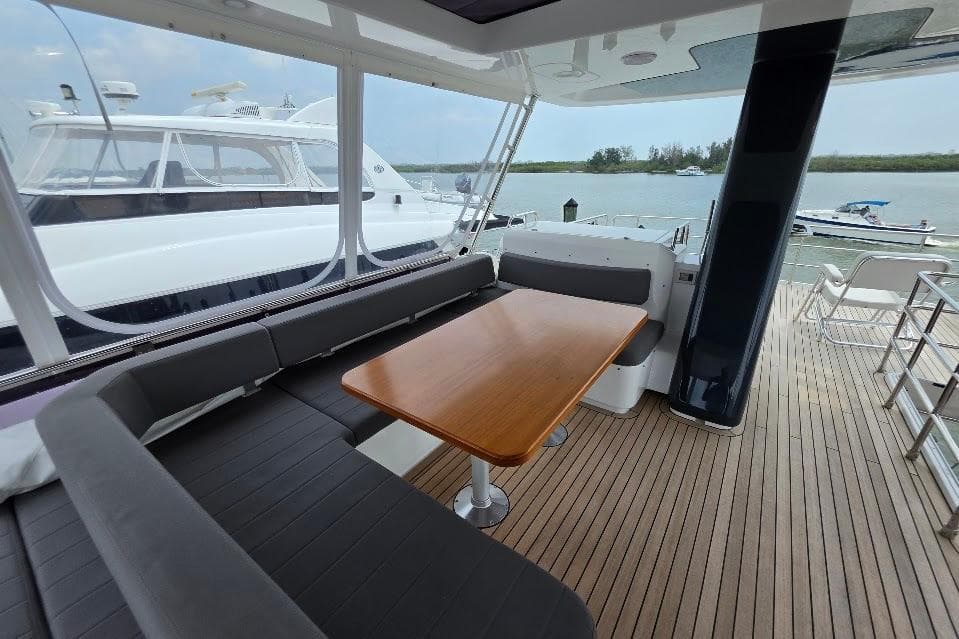 Luxurious 2024 Sirena 58 Flybridge yacht with elegant seating and wooden table on deck.