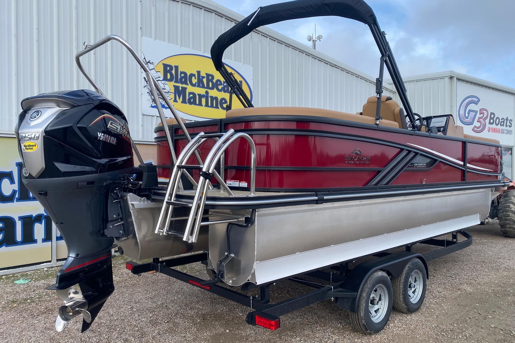 2026 SunCatcher Fusion 324RC pontoon boat on trailer at BlackBeard Marine dealership.
