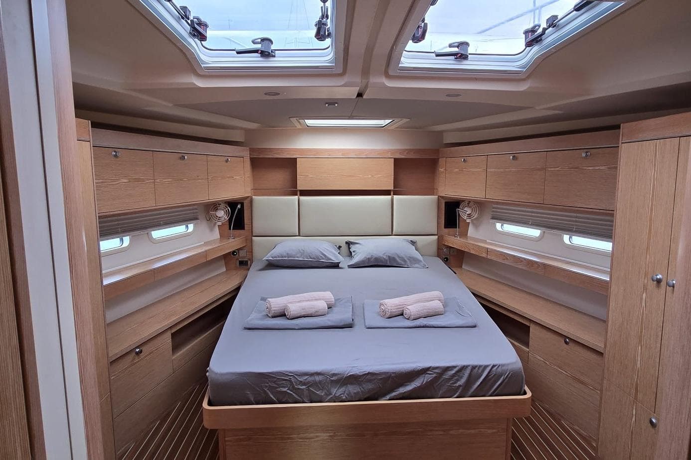 Luxurious cabin interior of 2015 Hanse 575 yacht with skylights and wooden furnishings.