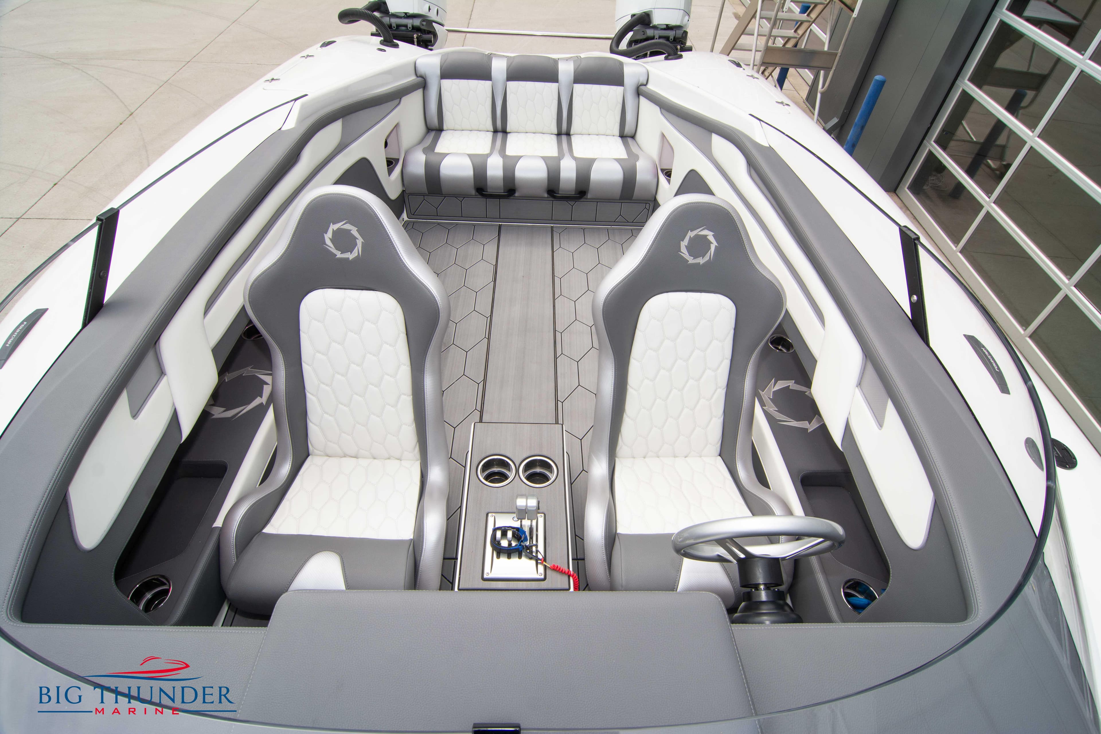 2023 Fountain 34 Thunder Cat interior with grey and white seating, steering wheel, and cup holders.