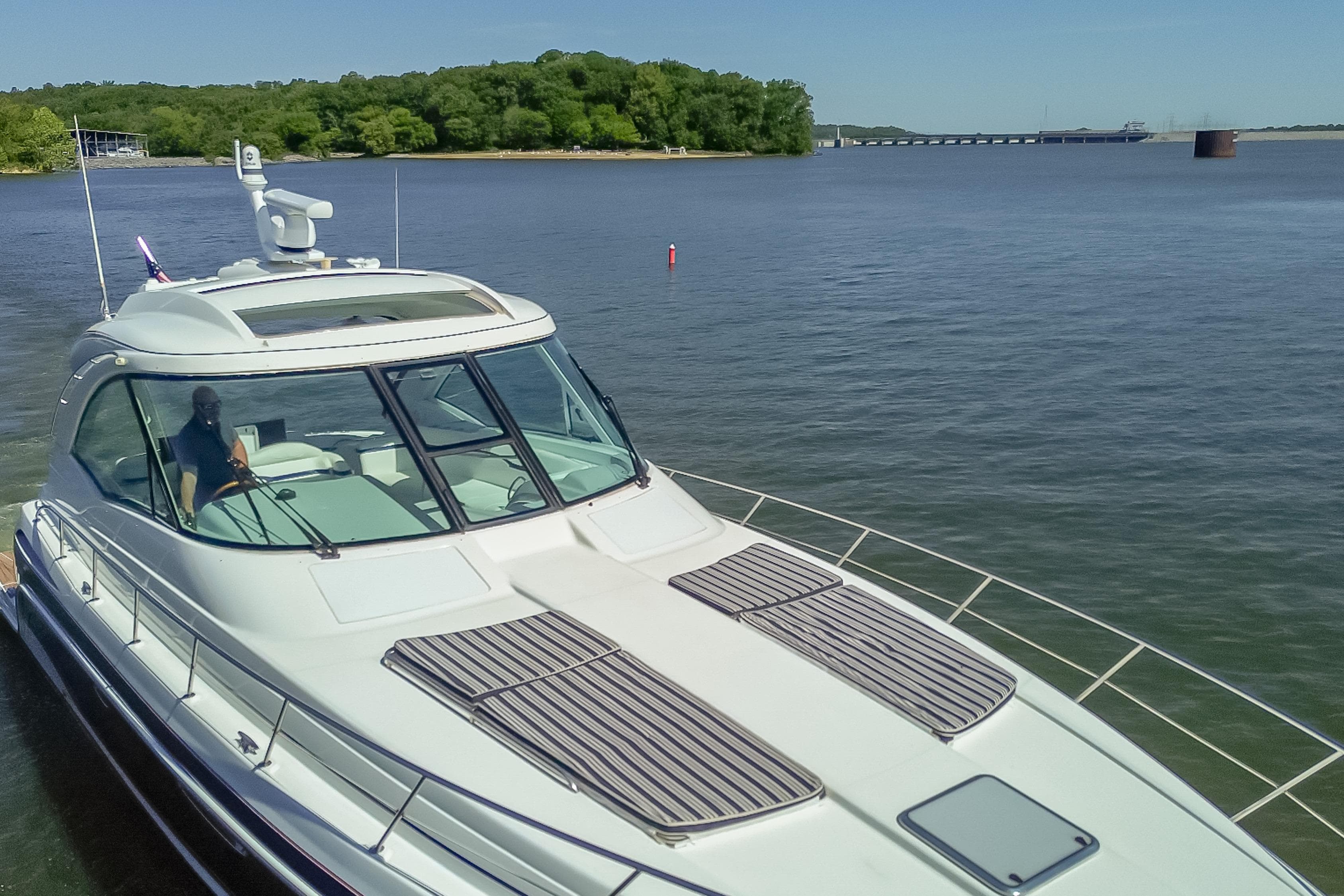2008 Formula 45 Yacht cruising on a serene lake with lush green shoreline.