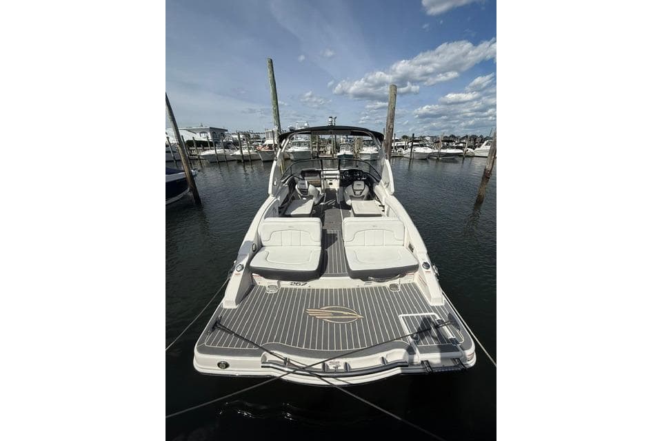 2015 Chaparral 257 SSX boat docked at marina under blue sky.