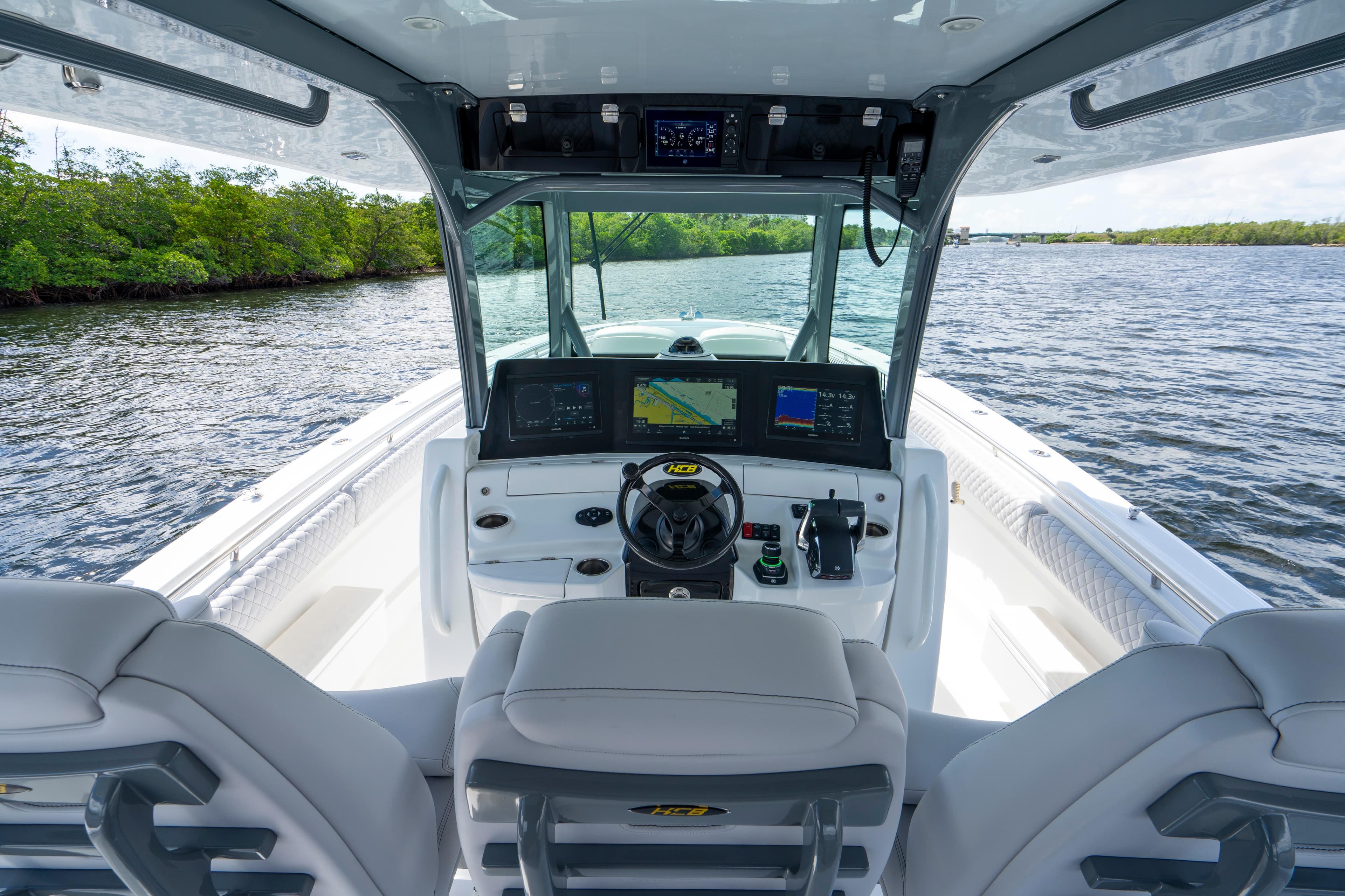 Helm of 2026 HCB 42 Lujo boat with advanced navigation systems on a scenic waterway.