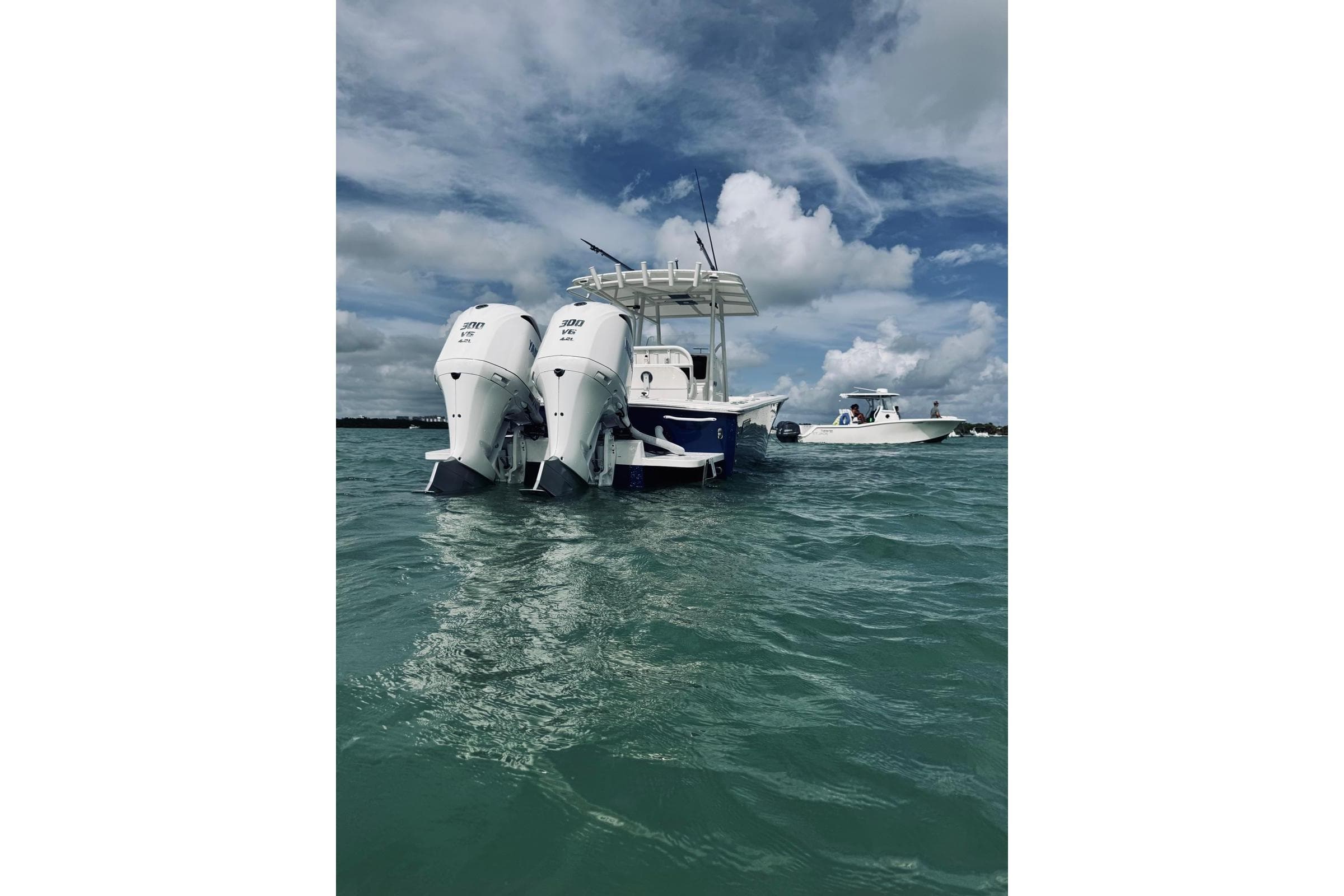 2005 Jupiter 31 boat with twin outboard engines on open water under cloudy sky.