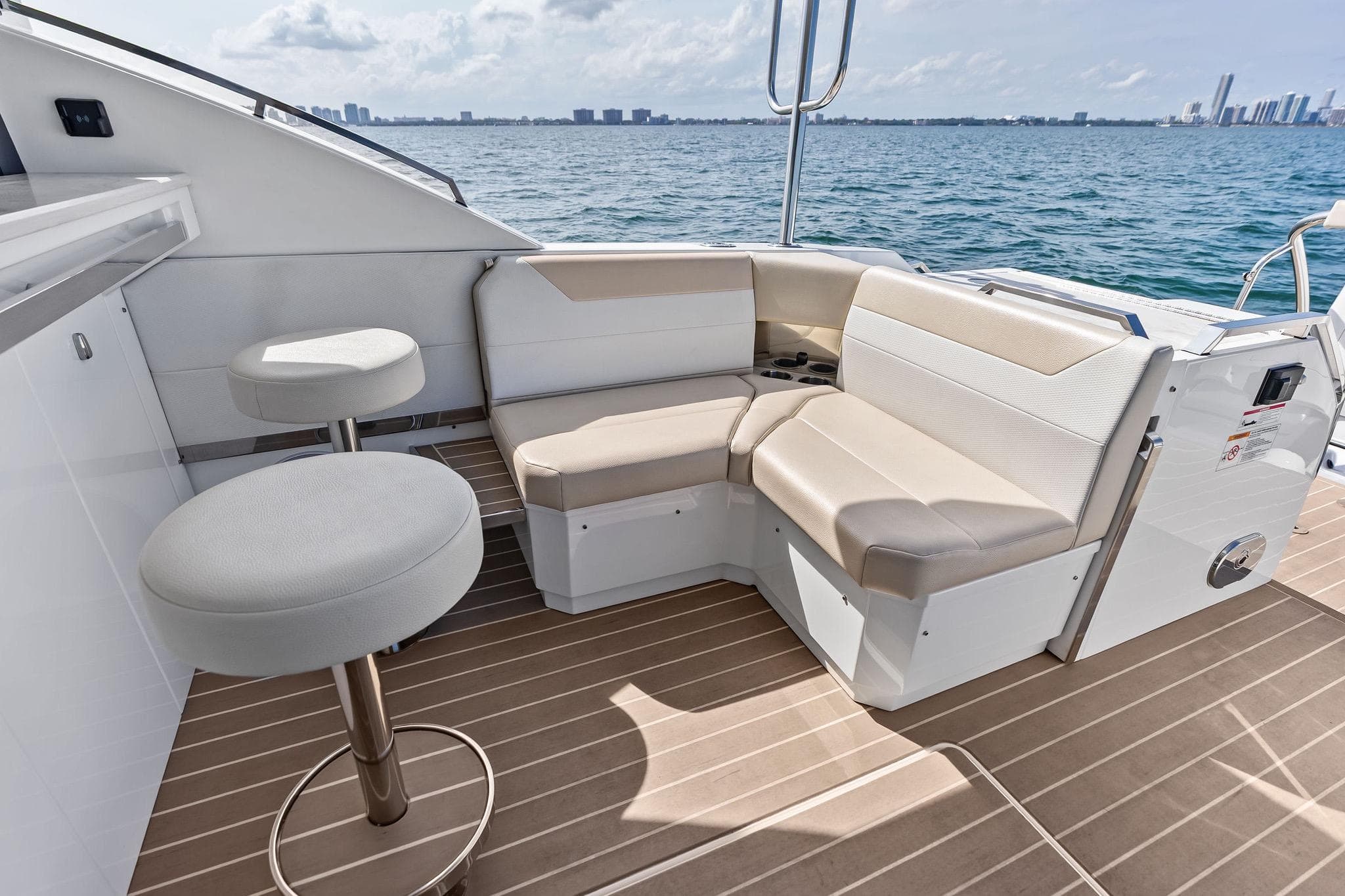 Luxurious seating area on 2025 Formula 500 Super Sport Crossover yacht, overlooking ocean skyline.